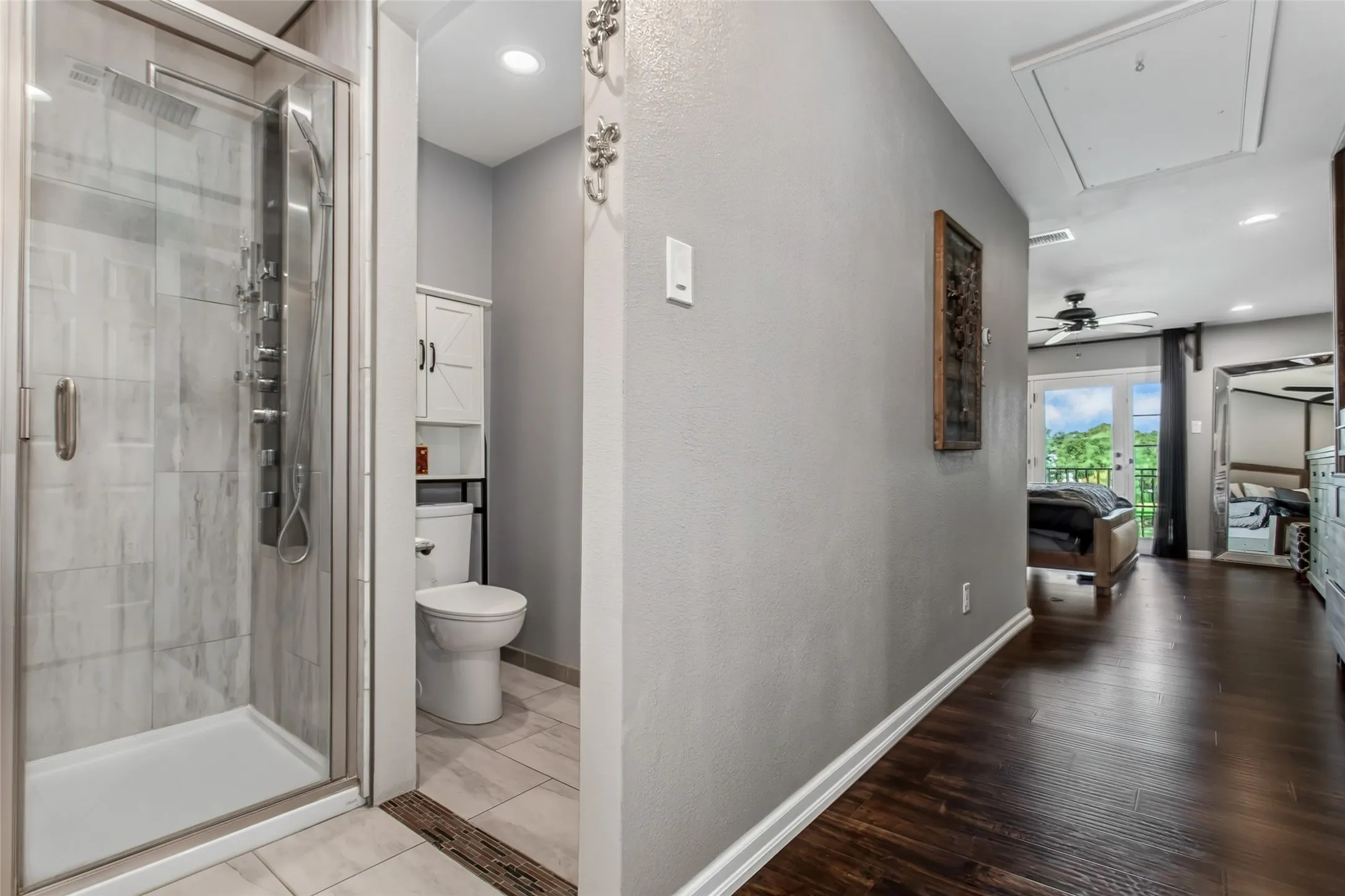 Walk-in shower with glass enclosure and multi-function shower panel