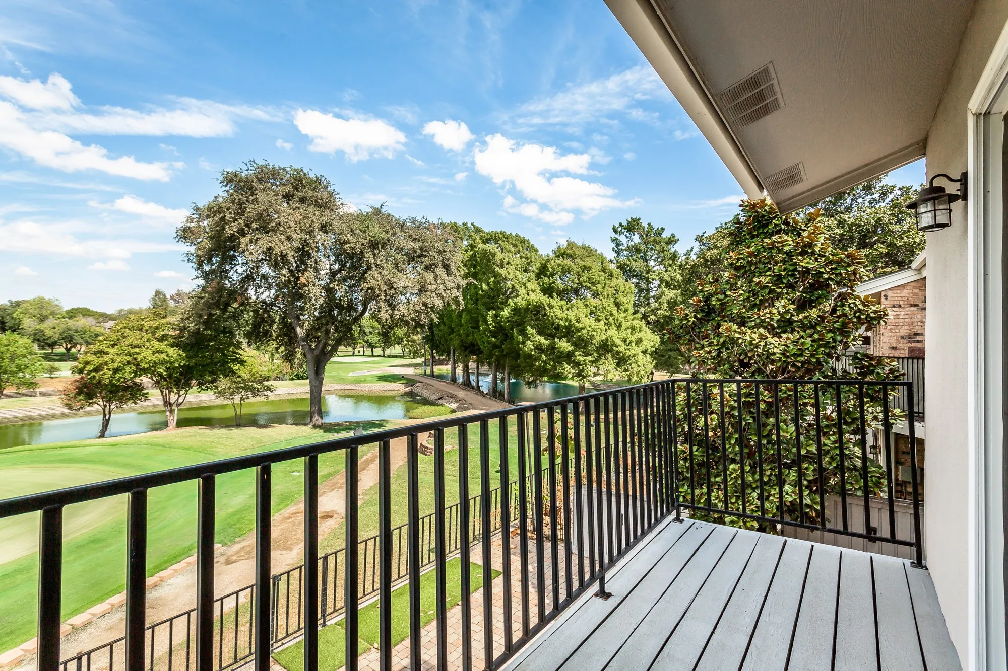 Balcony featuring a black metal railing and white wood-finish flooring