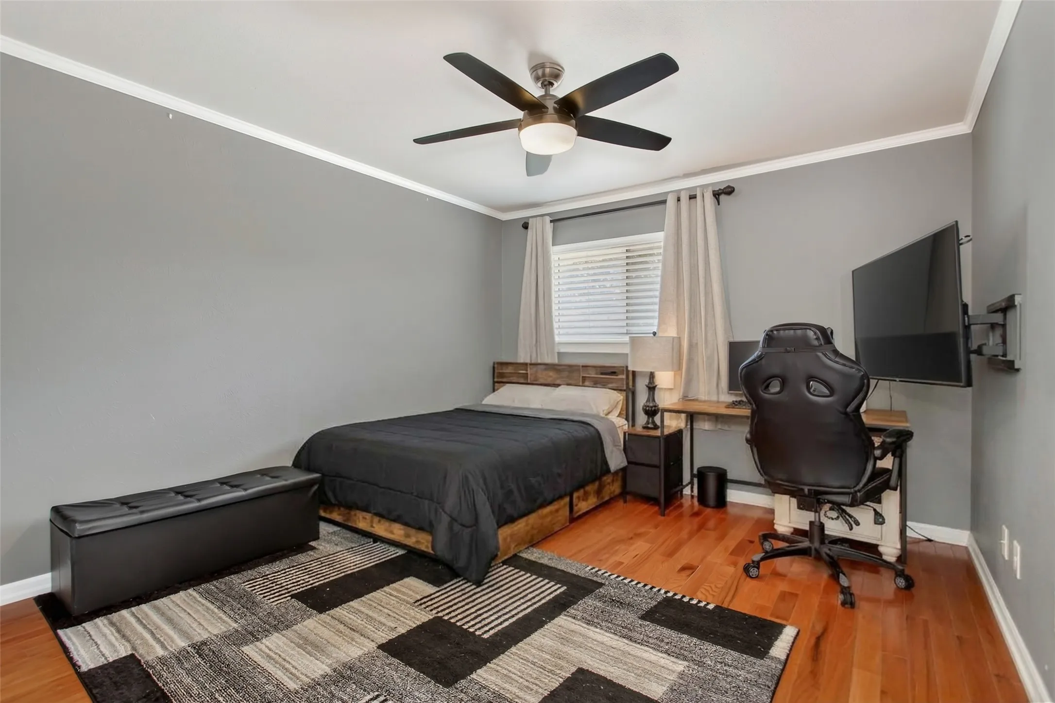 Hardwood flooring, crown molding, ceiling fan with integrated lighting, and window with blinds