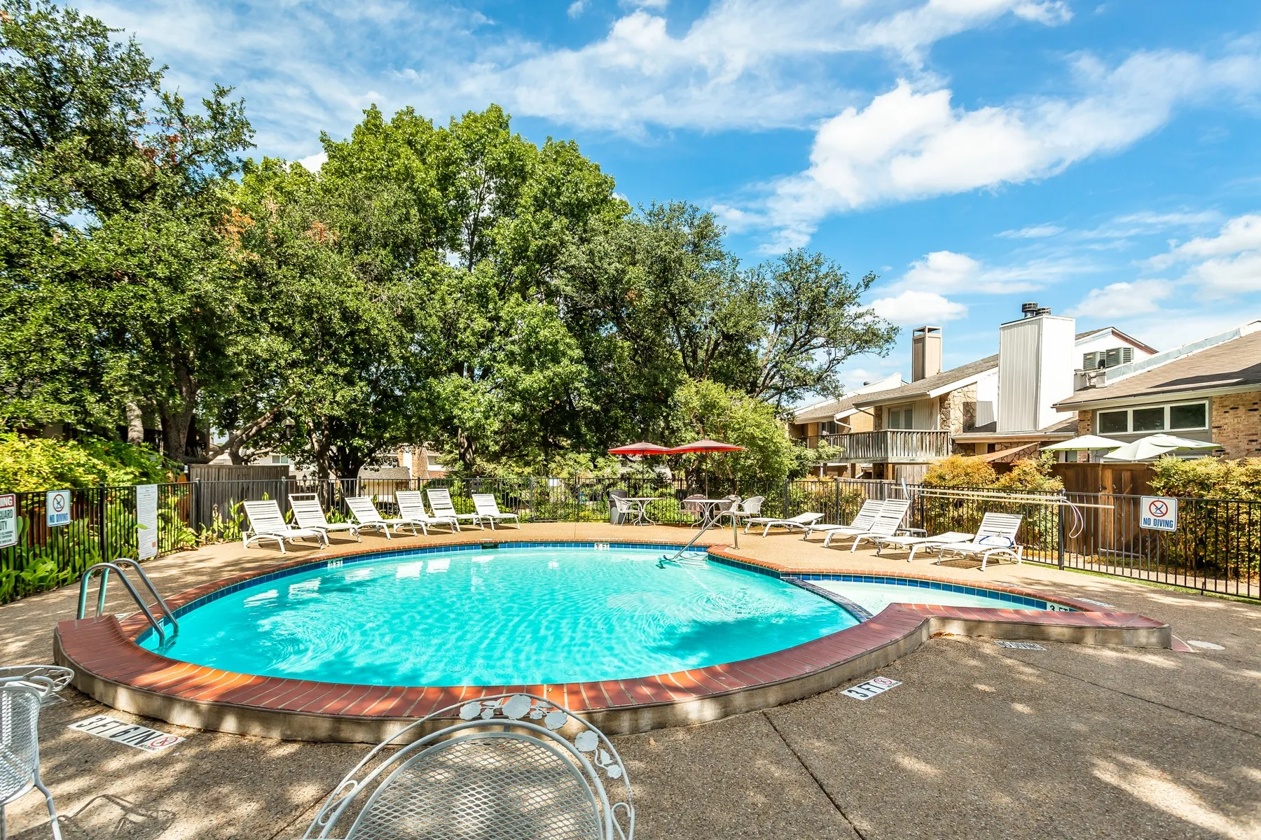 Circular swimming pool with a brick-coping edge and surrounding concrete deck