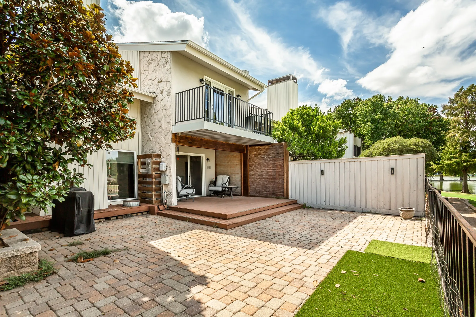 Spacious multi-level paver patio with a raised wood-finish deck