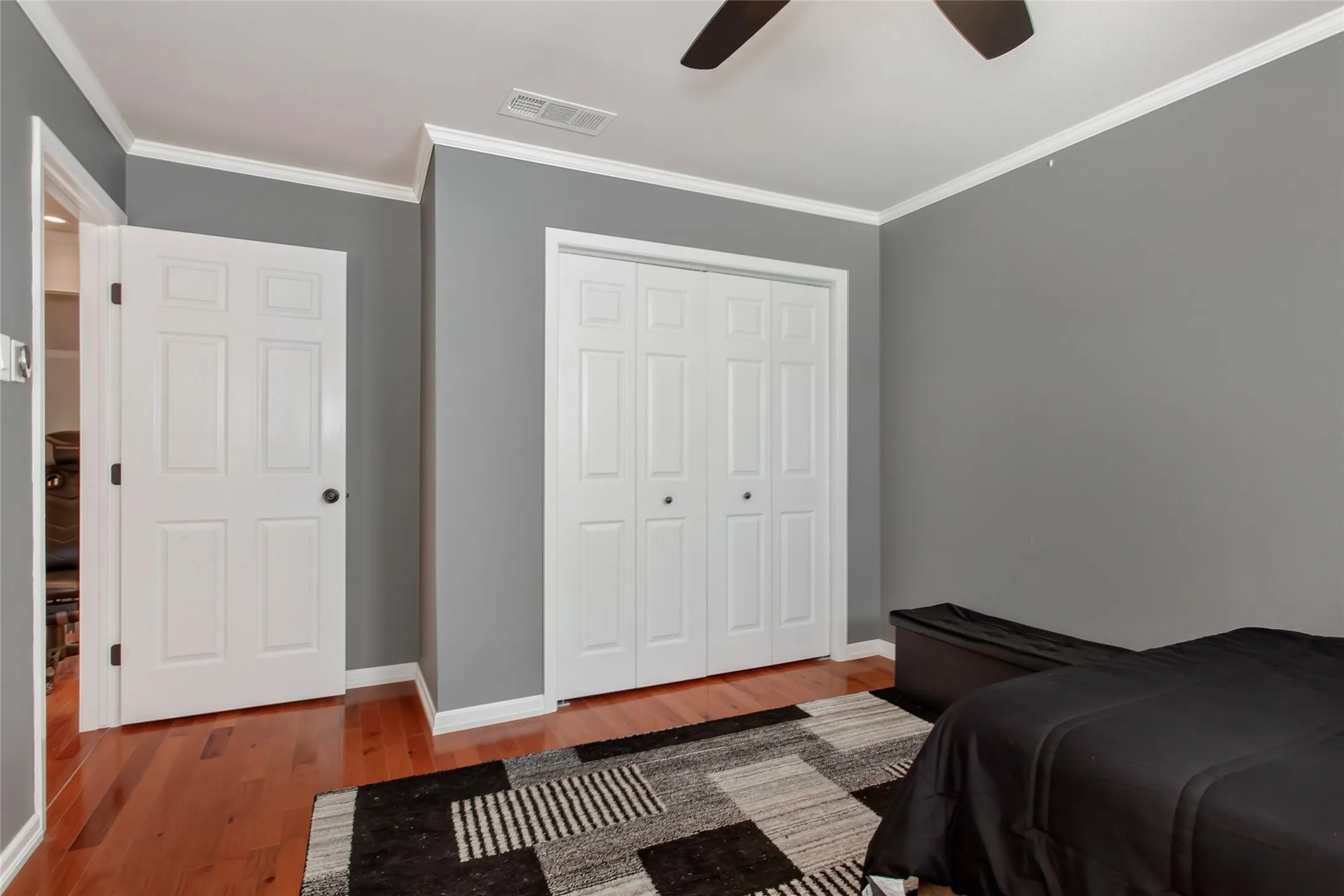 Hardwood-finish flooring with white trim and crown molding