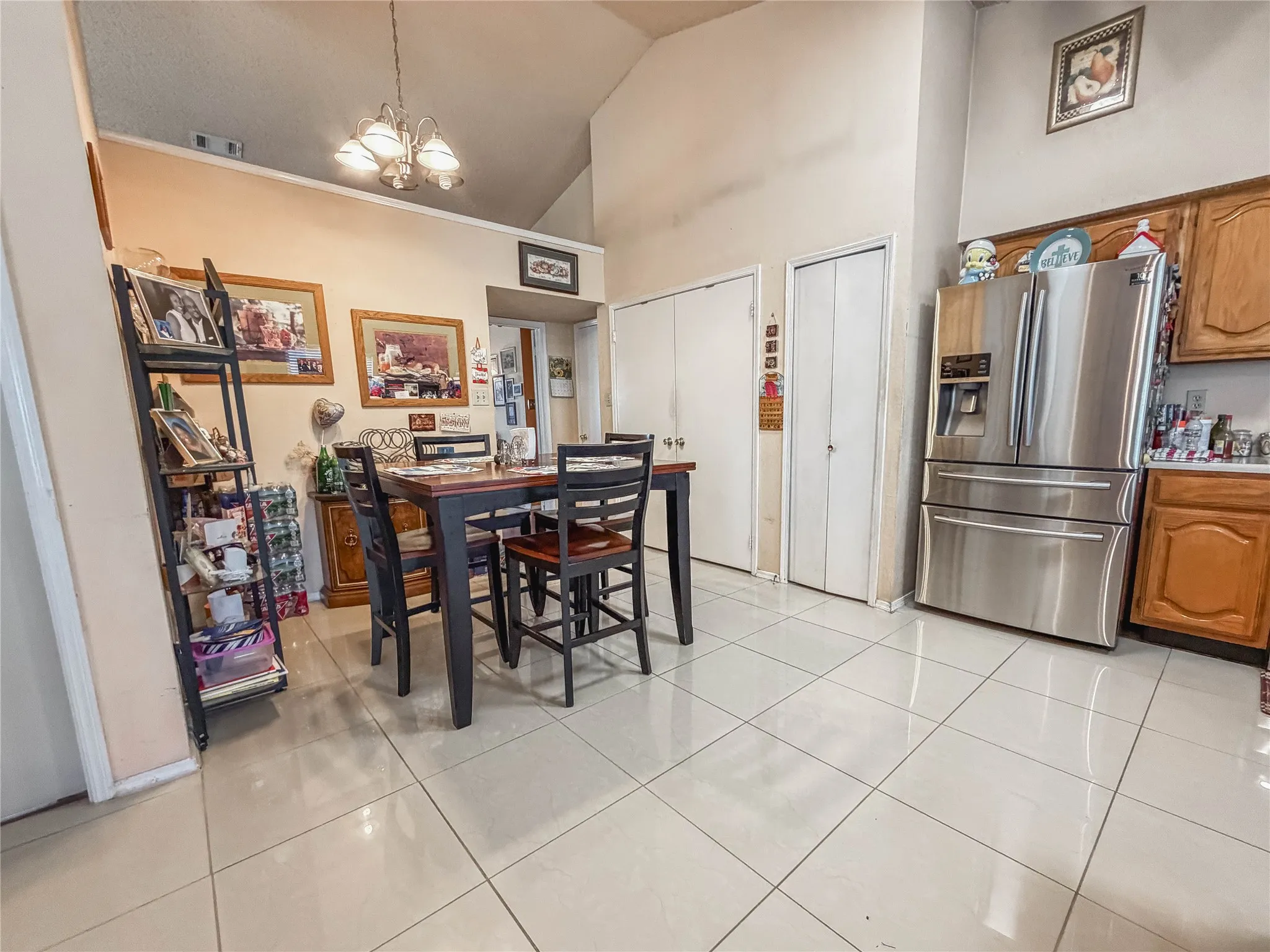 Vaulted ceiling, recessed lighting, and light-toned tile flooring