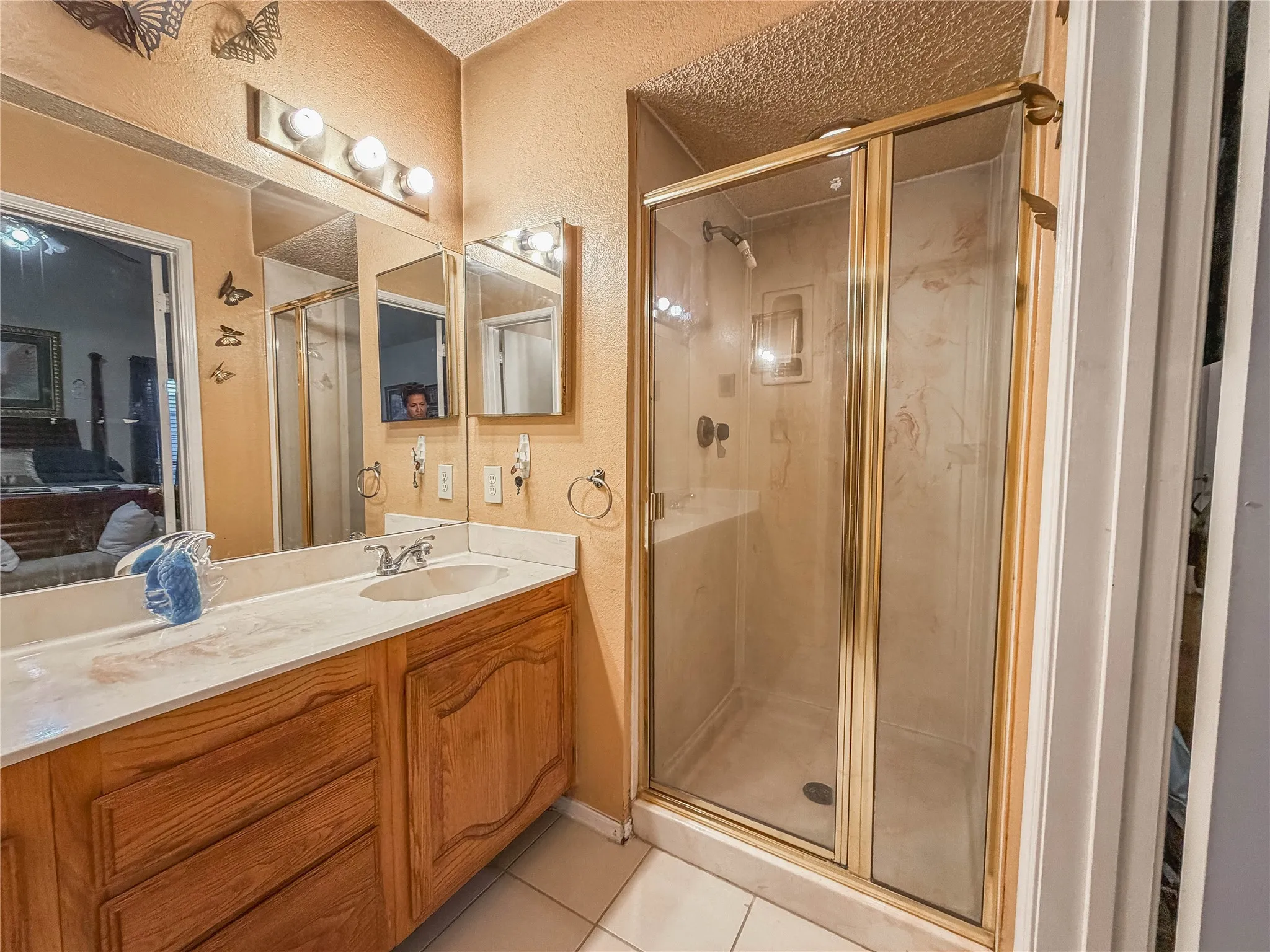 Vanity with an integrated sink and wood-finish cabinetry, illuminated by a four-bulb fixture