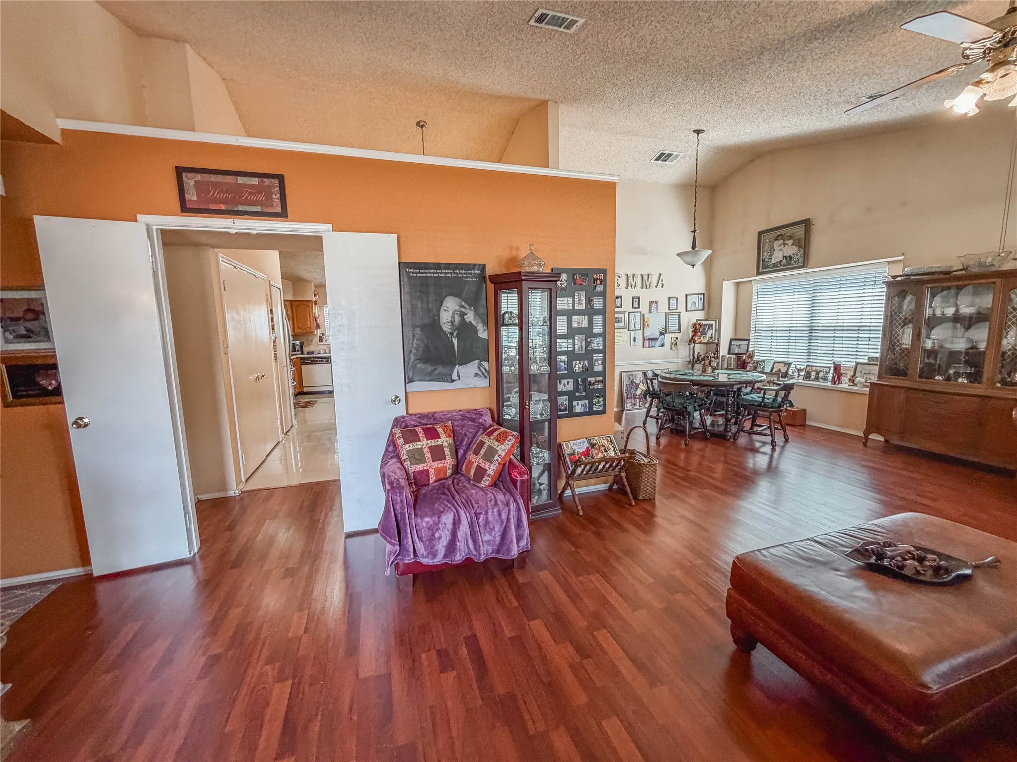 Wood-finish flooring throughout, vaulted ceilings, open concept living area, dining area with window seating, and a ceiling fan