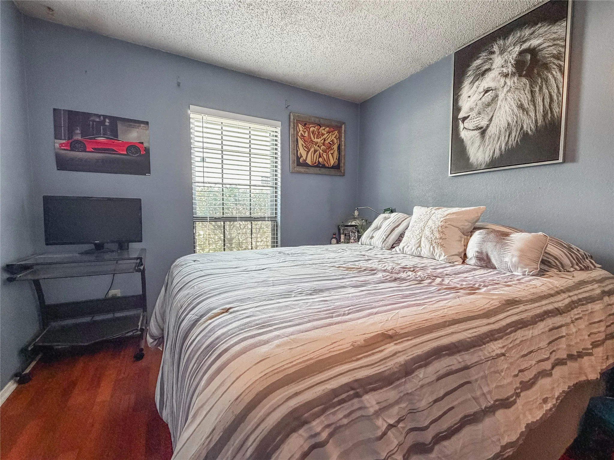 Wood-finish flooring, a window with blinds, and light blue wall color