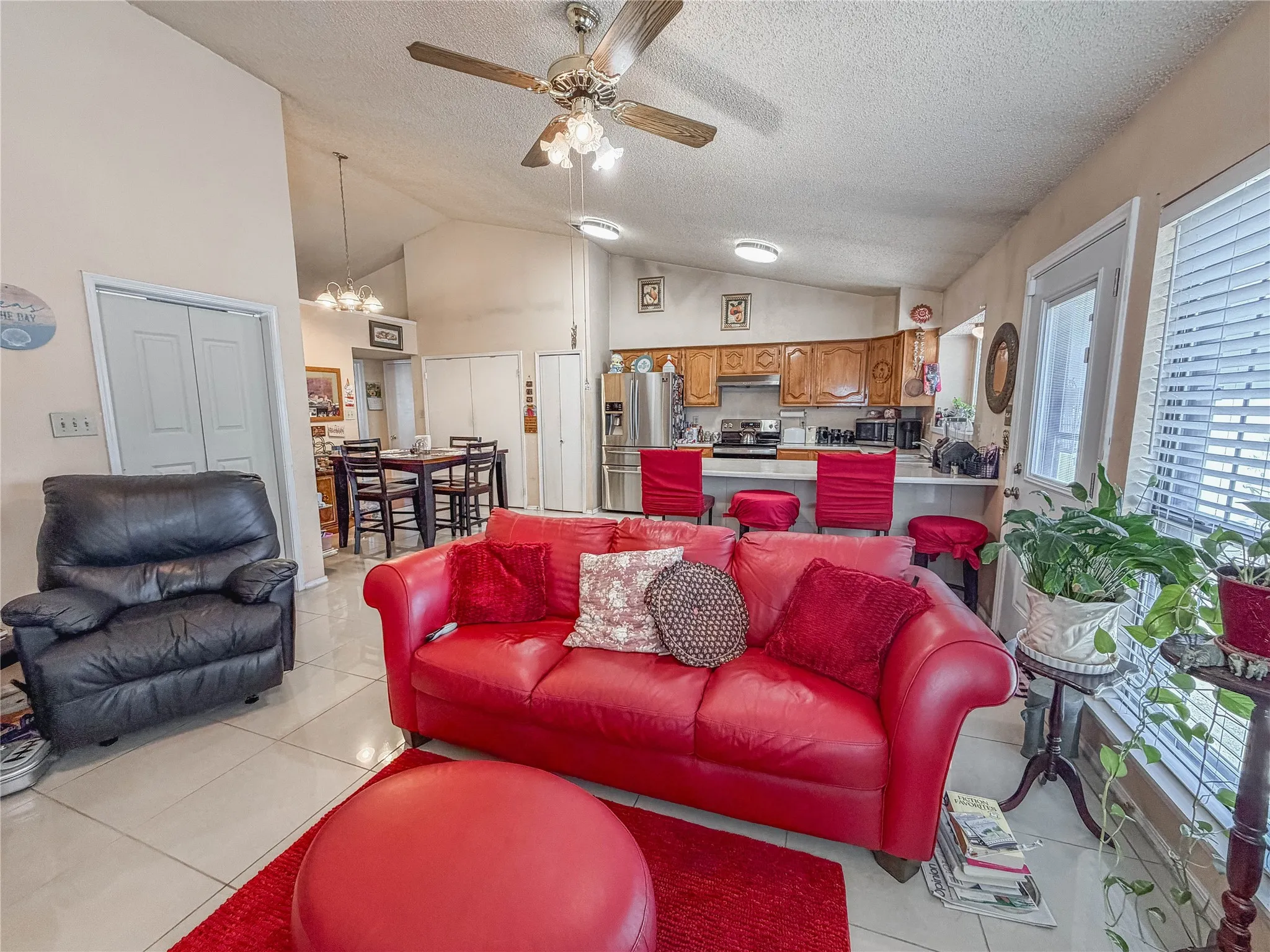 Vaulted ceiling with ceiling fan, tile flooring, recessed lighting, double-pane window with blinds, and white panel doors