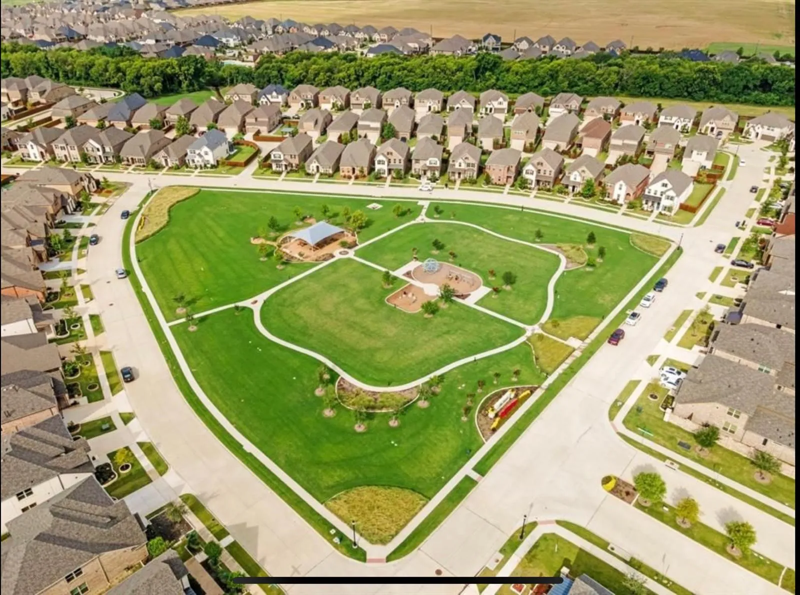 Central green space featuring manicured lawns and paved walking paths