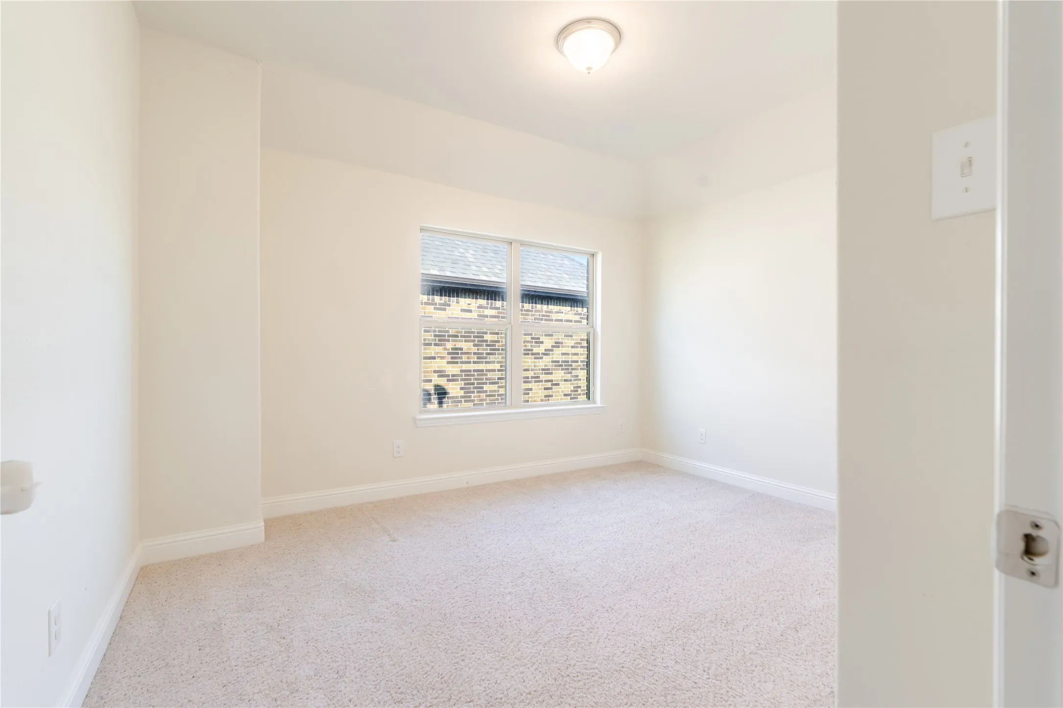 Carpeted room featuring a single window, a flush mount ceiling light, and light-toned walls