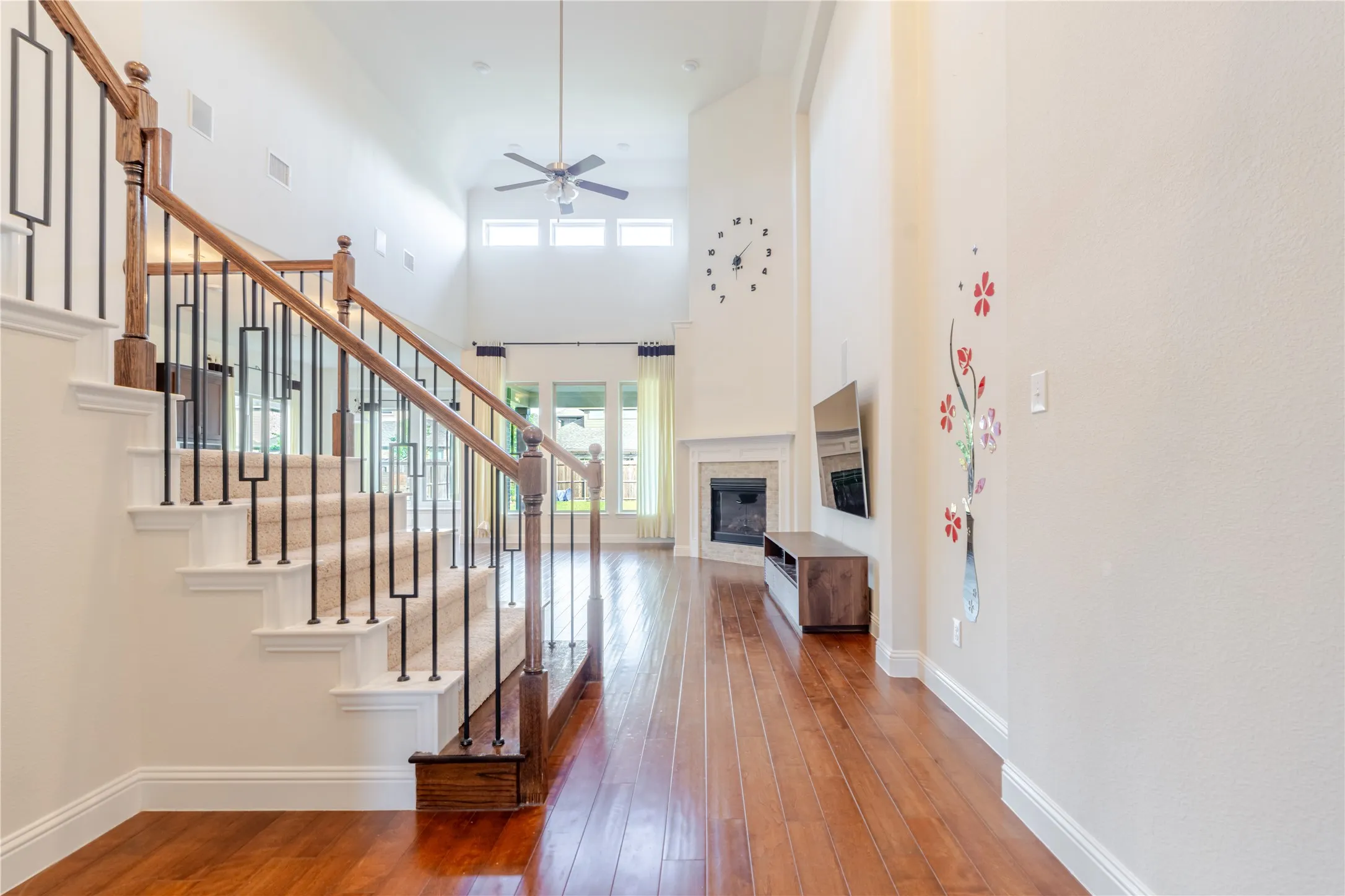 Staircase with wood newel posts, handrails, and wrought iron balusters