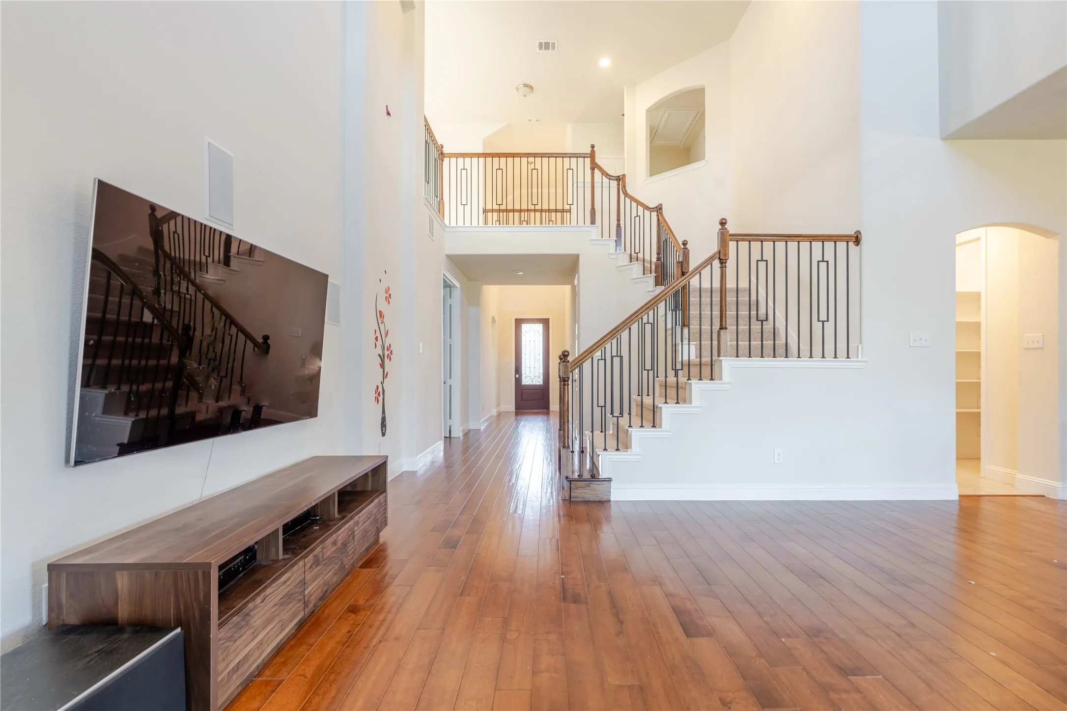 Grand entry foyer featuring a sweeping staircase with wood handrails and wrought iron balusters