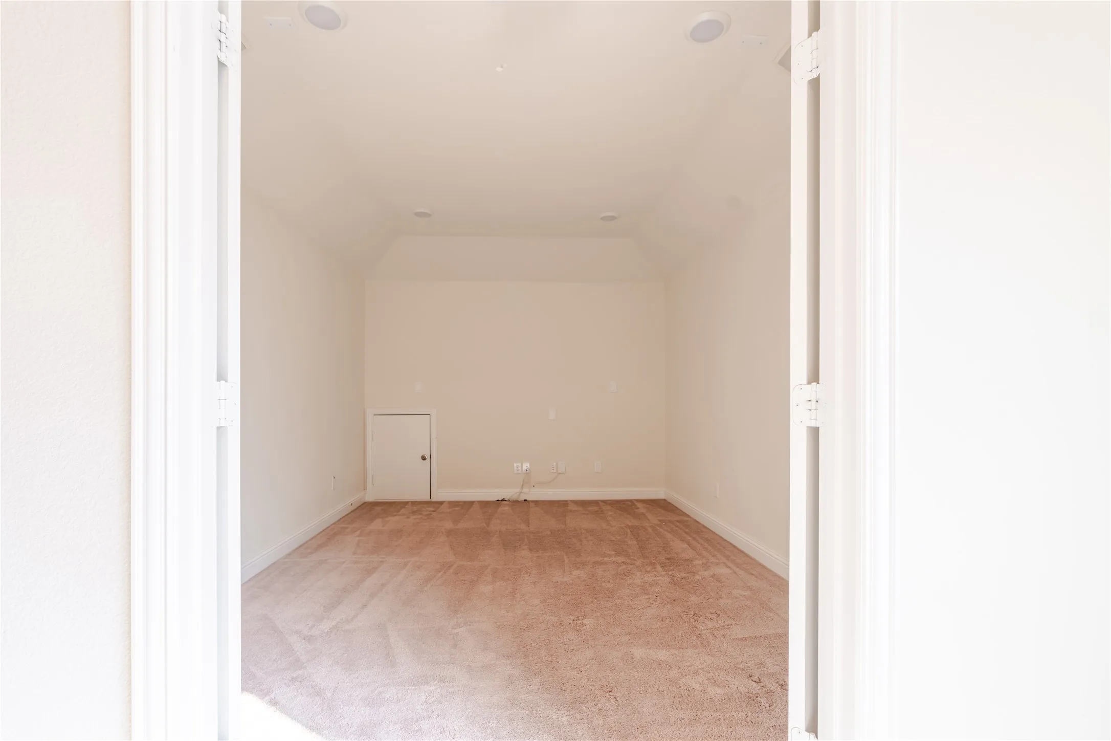Carpeted room featuring a vaulted ceiling, recessed lighting, base molding, and a built-in access panel