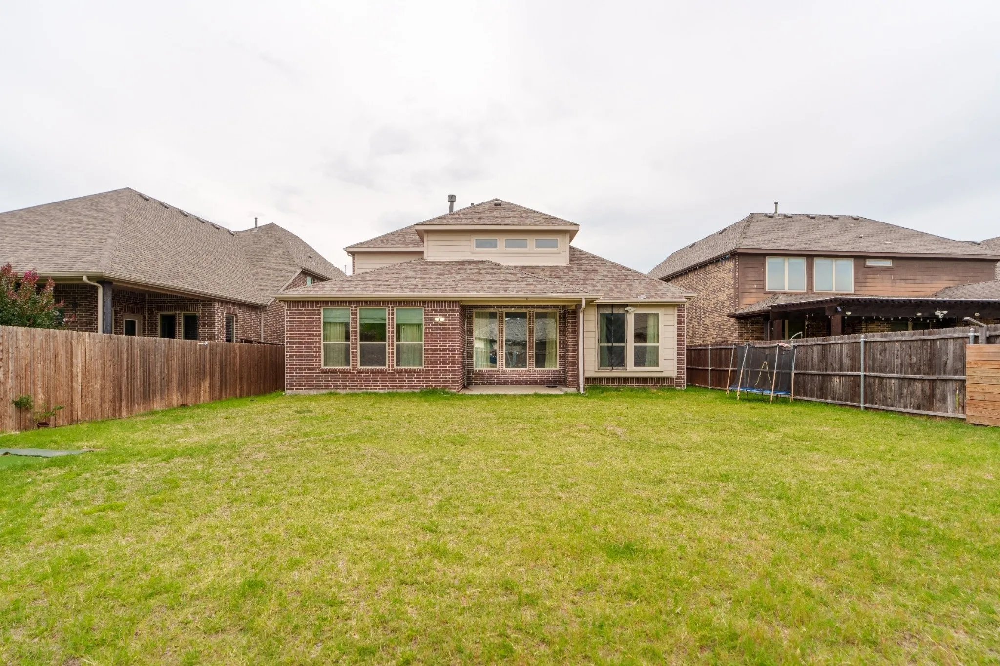 Expansive green lawn with a full privacy fence