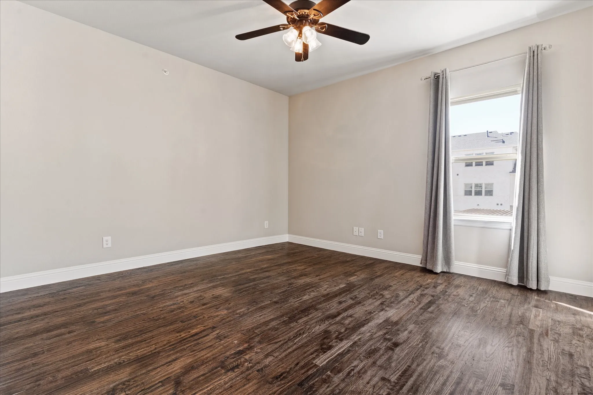 Wood-finish flooring, recessed window, white trim, and a ceiling fan with integrated lighting