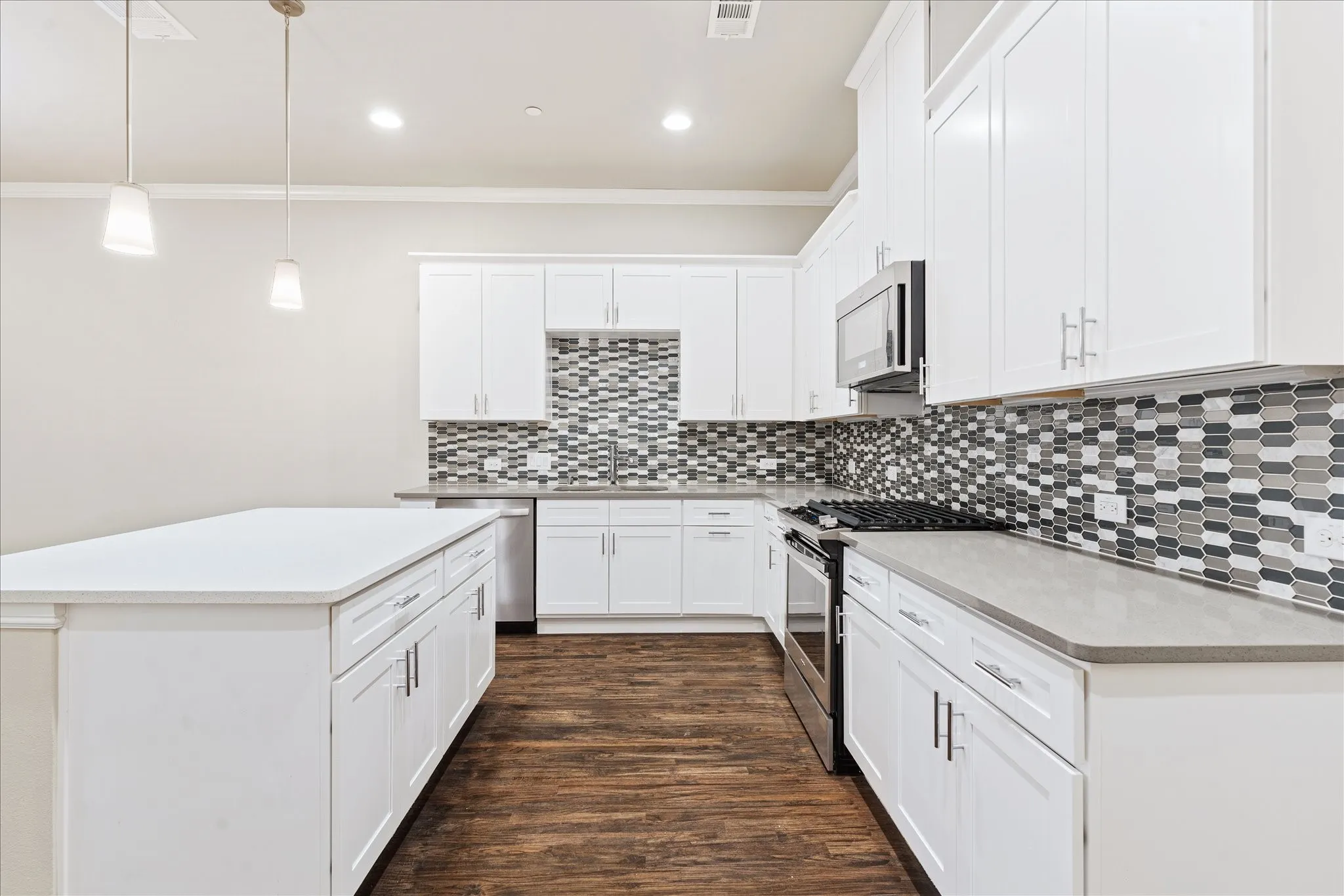 Kitchen featuring white shaker-style cabinetry, a contrasting mosaic tile backsplash, wood-finish flooring, recessed lighting, and stainless steel appliances