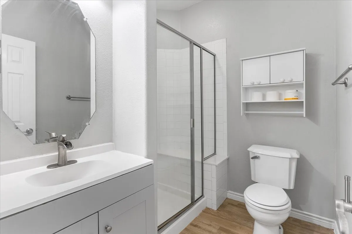 Bathroom featuring a shower with glass enclosure, white square tile, and built-in bench