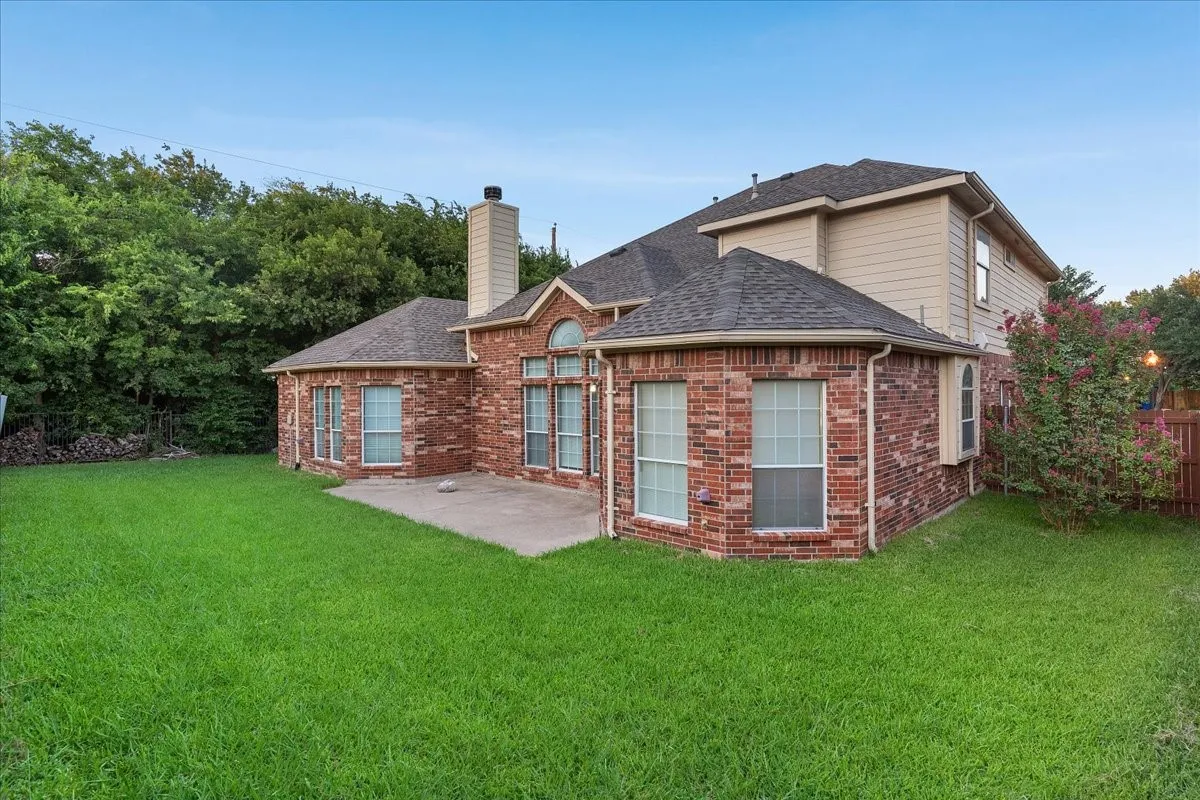 Expansive green lawn bordering a brick and siding exterior