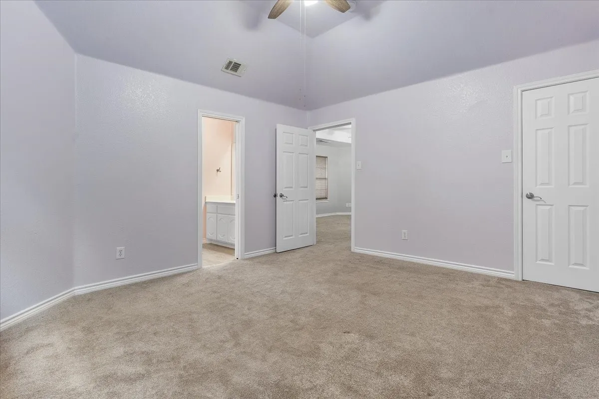 Spacious room featuring neutral carpet flooring and light-toned walls