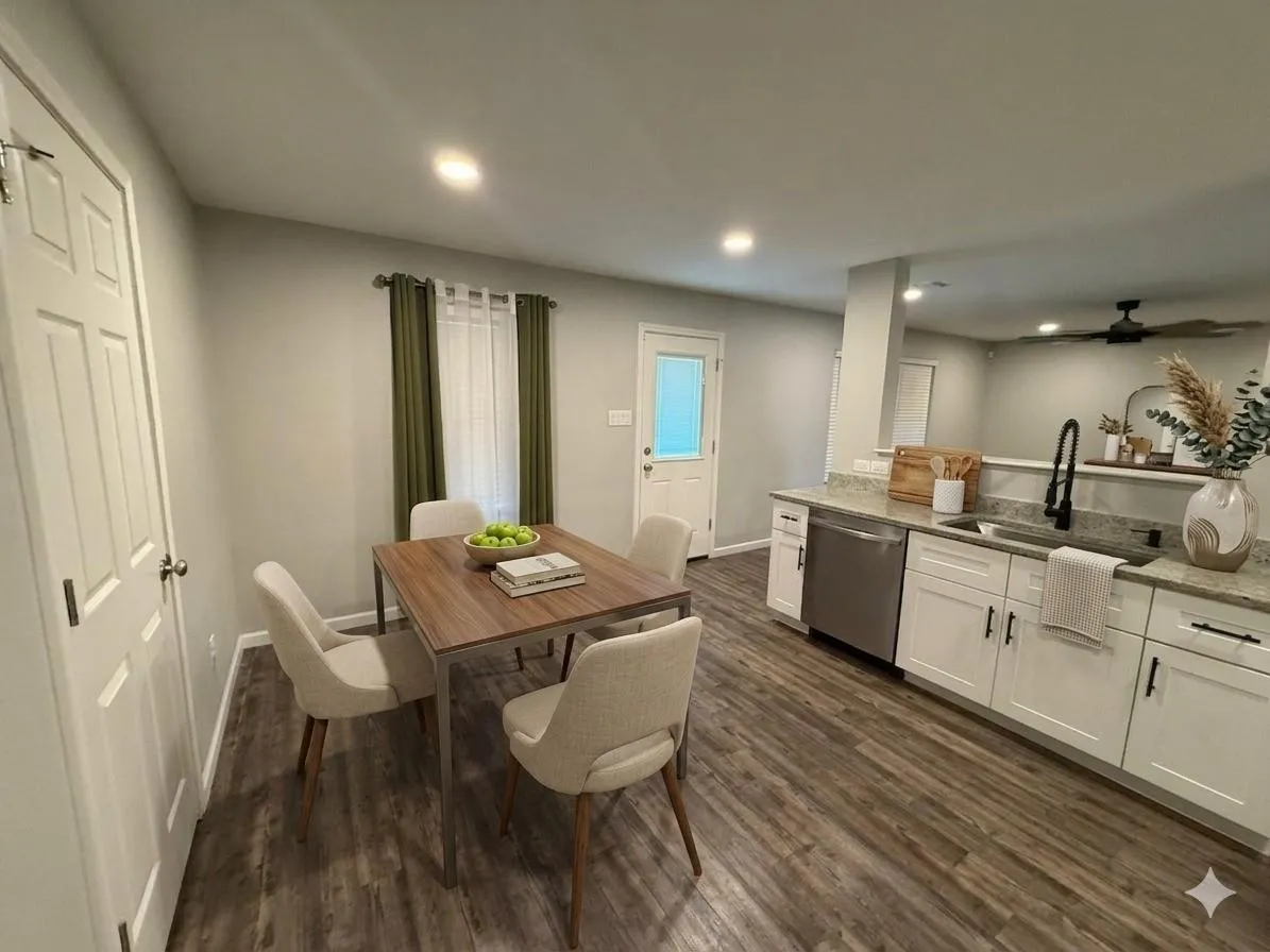 Wood-finish flooring throughout, white shaker cabinetry with dark hardware, stainless steel dishwasher, light-toned countertops, and recessed lighting
