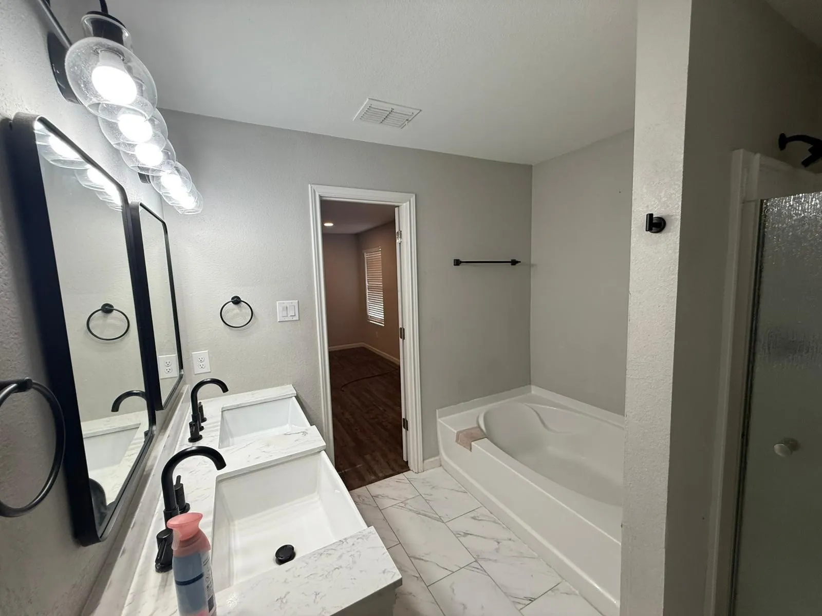 Dual vanity with undermount sinks, matte black fixtures, and framed mirrors