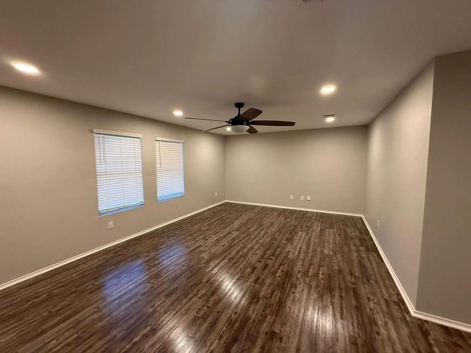 Recessed lighting, ceiling fan, wood-finish flooring, two windows with blinds, and neutral wall tones