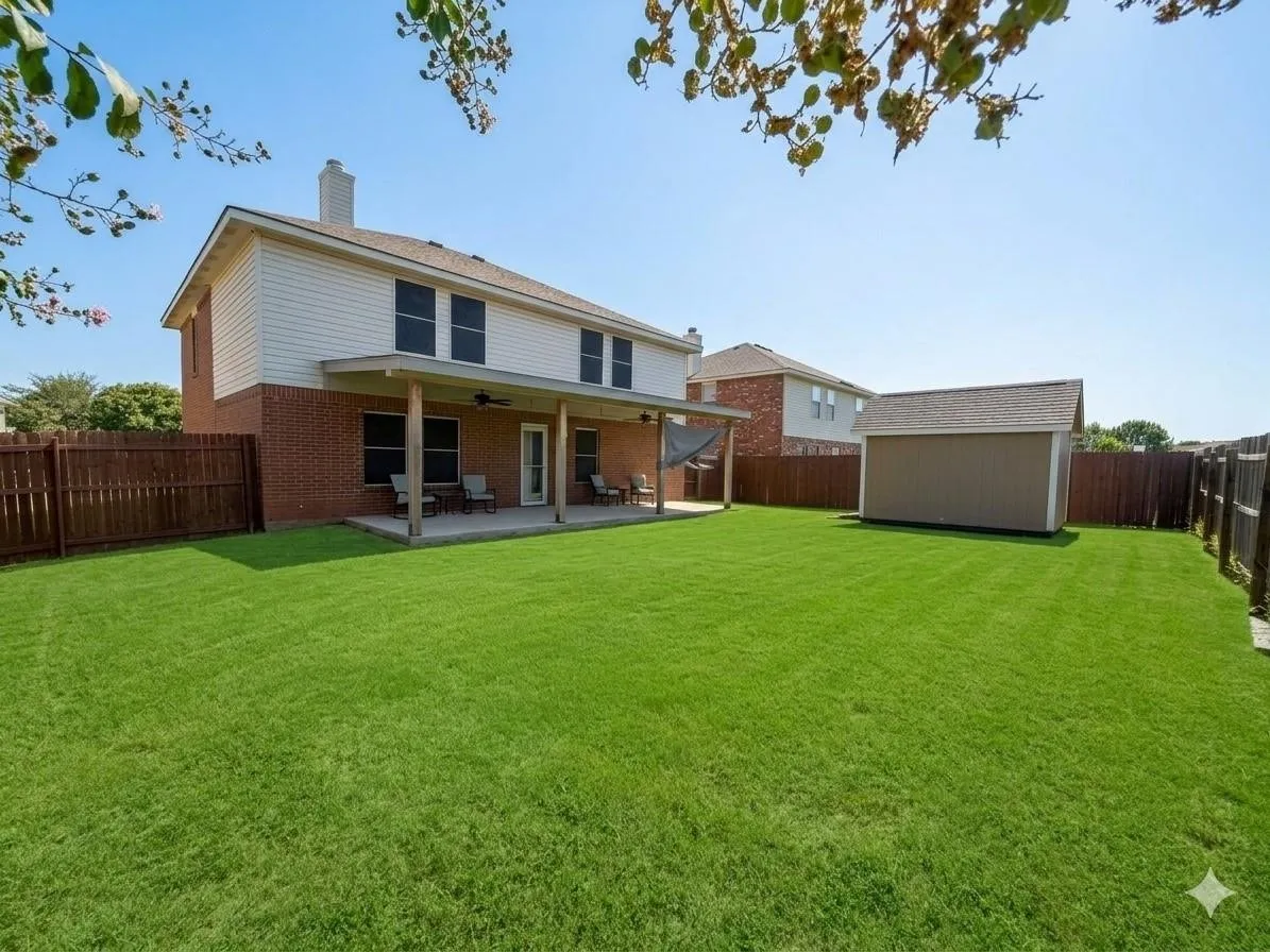 Expansive backyard featuring a manicured lawn, a covered patio, and a storage shed