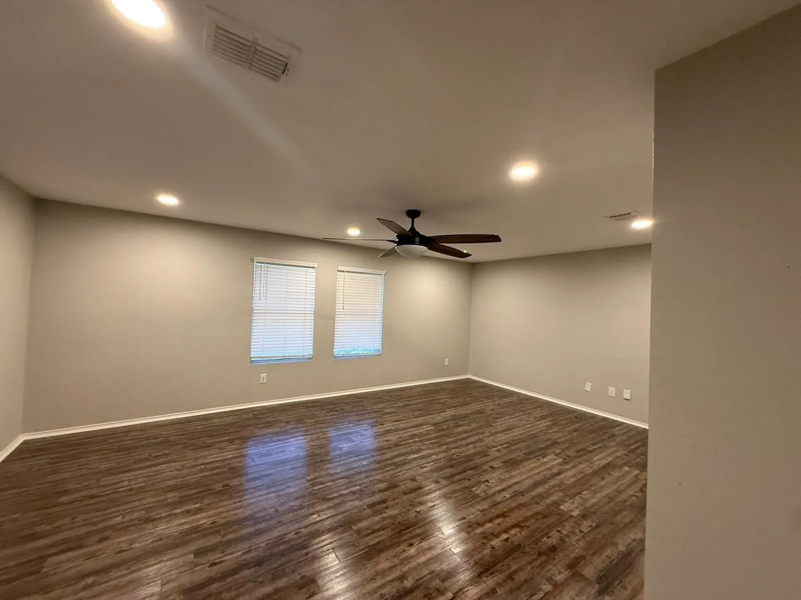 Wood-finish flooring throughout, recessed ceiling lighting, and a ceiling fan