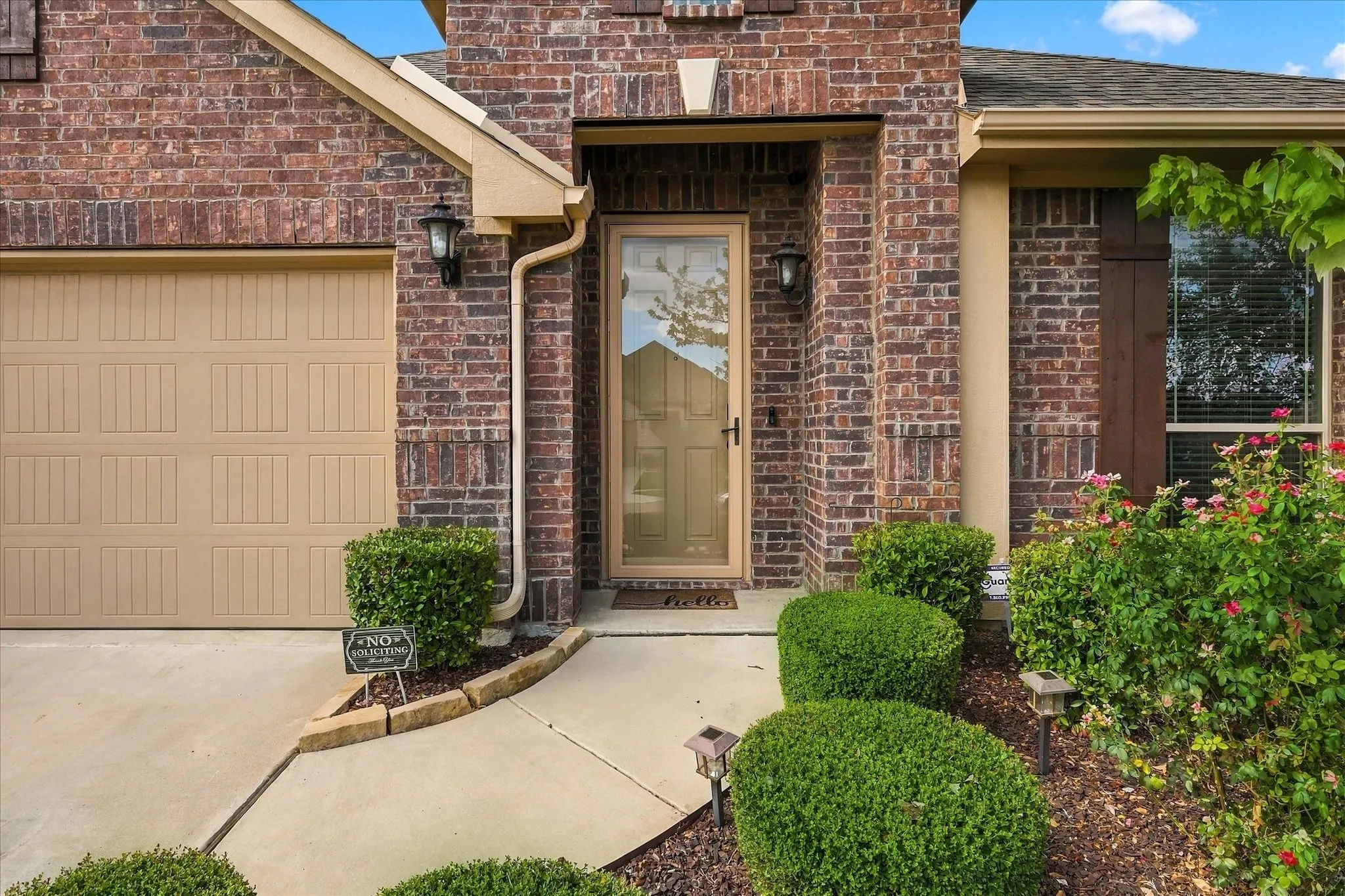 Brick exterior with a paneled garage door and a glass-paneled entry door