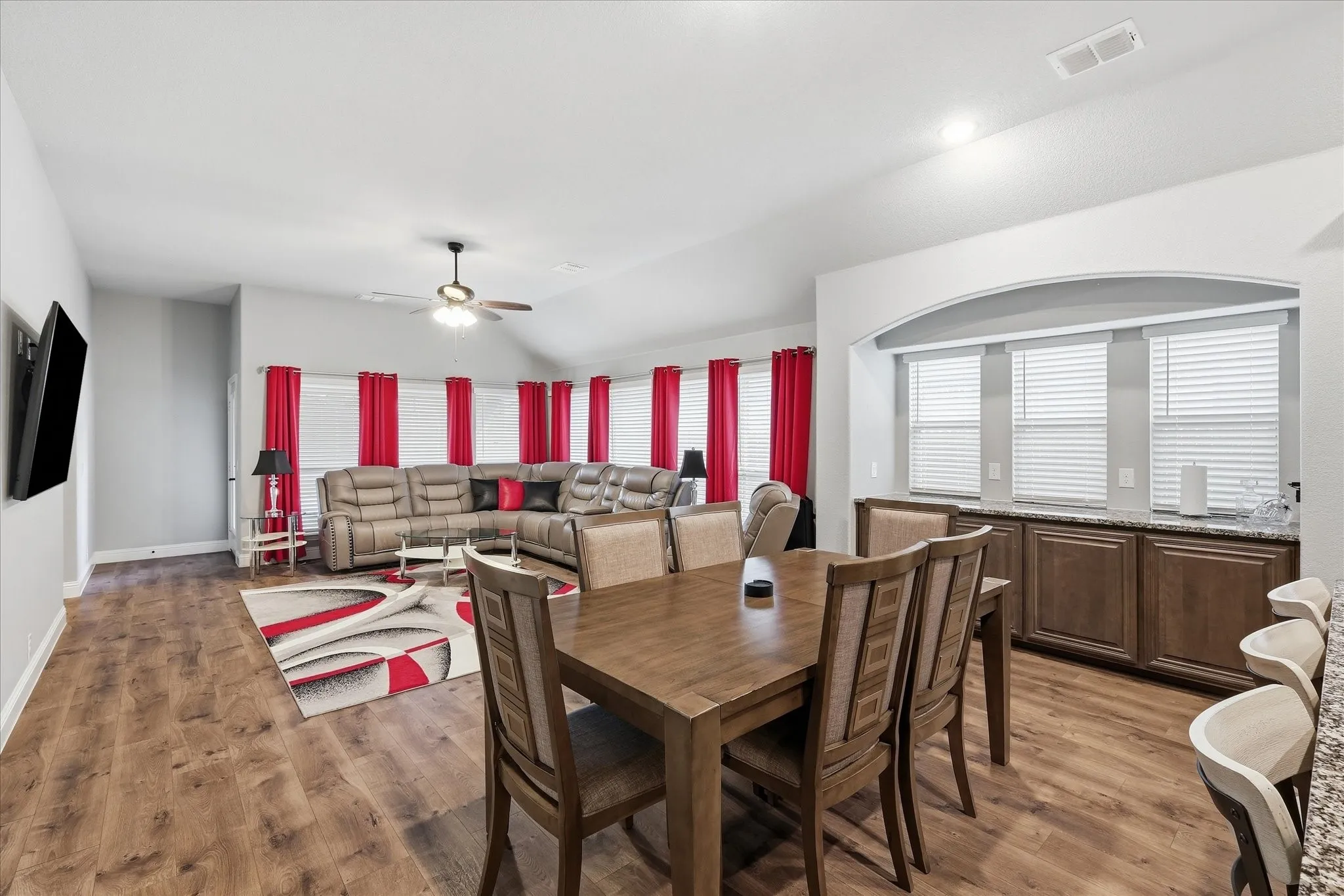 Vaulted ceiling, wood-finish flooring, recessed lighting, built-in cabinetry, and integrated ceiling fan