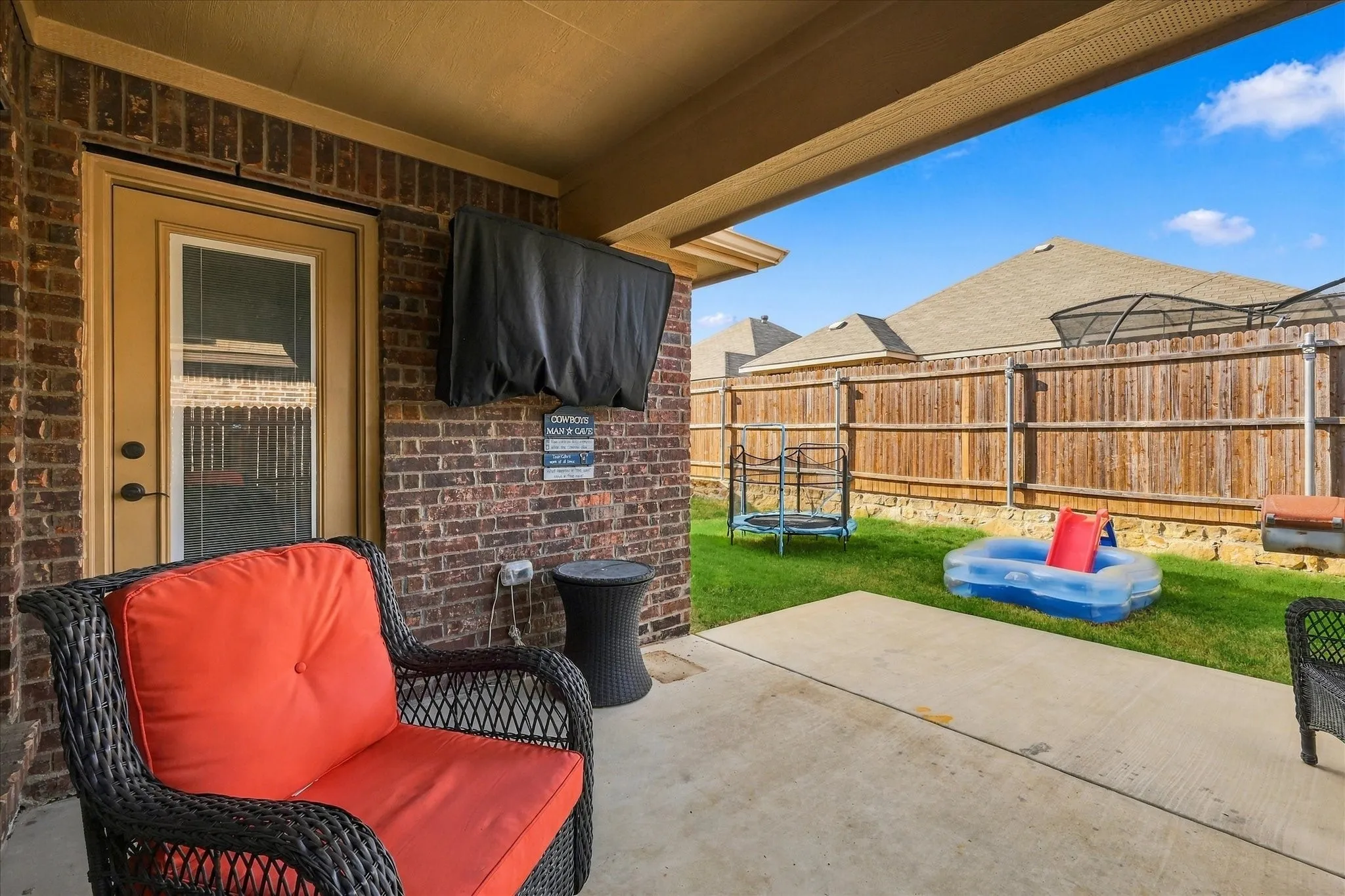 Covered patio with brick wall and concrete flooring