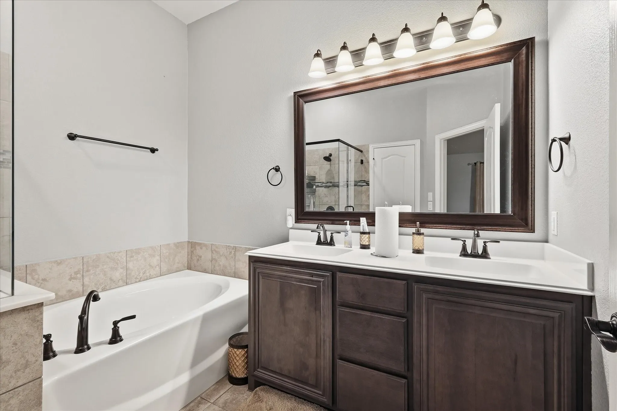Dual vanity with undermount sinks, framed mirror, and five-light fixture