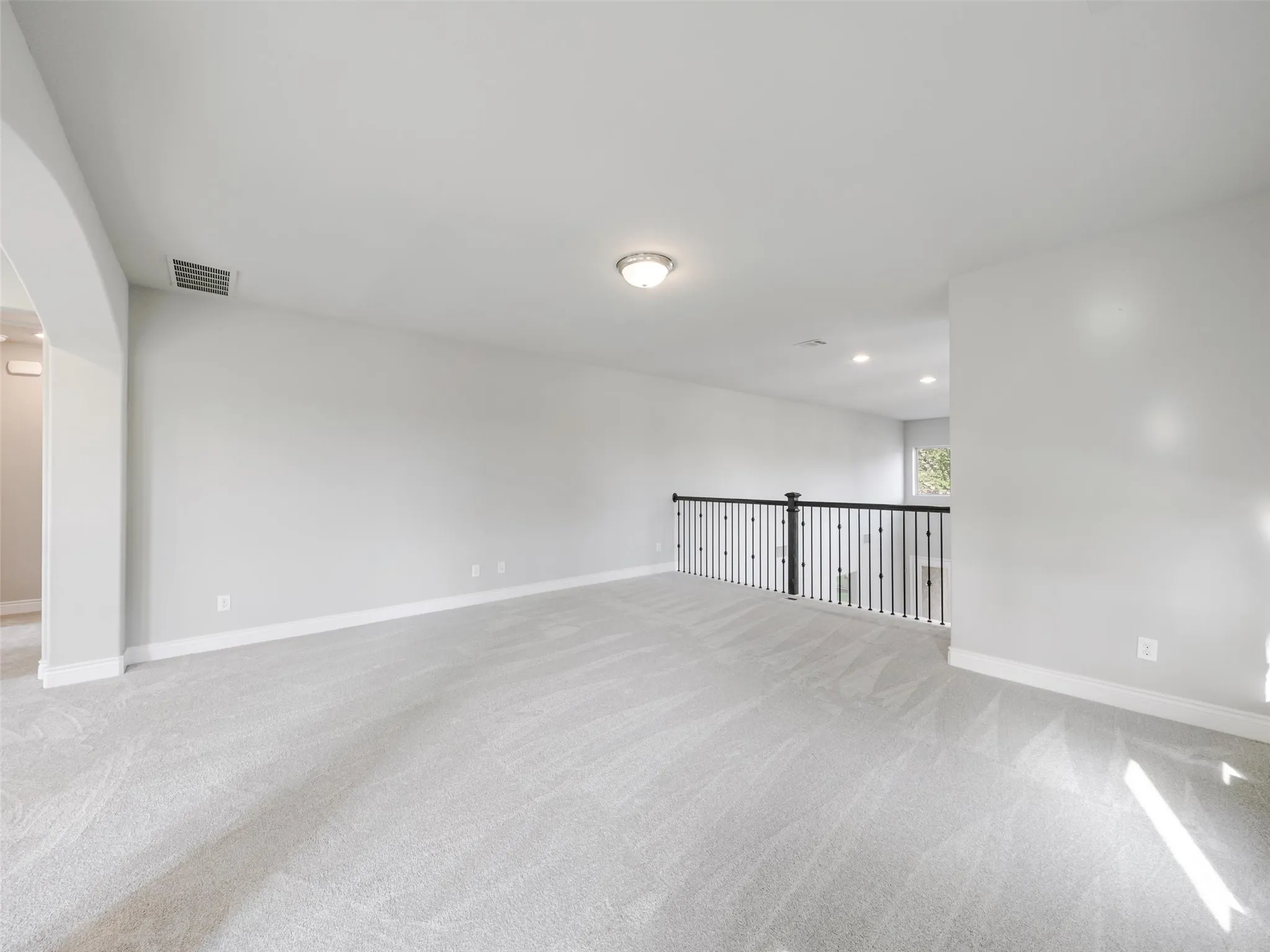 The game room provides a versatile area for recreation, movies, hobbies, or an additional lounge. A balcony overlooking the living room below enhances the home's open design and provides a dramatic view of the cathedral ceiling and main gathering space.