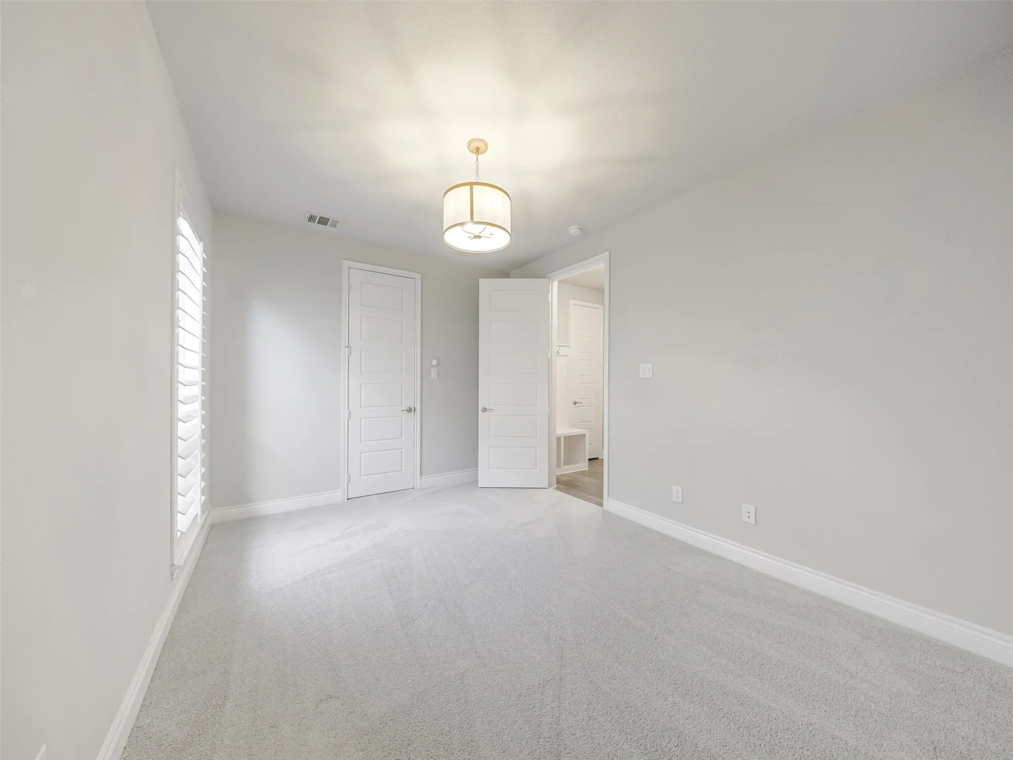 A secondary bedroom located on the first floor offers additional flexibility and privacy. Complete with its own walk-in closet and private ensuite bathroom, this space is well suited for overnight guests, extended stays, or a private secondary suite.