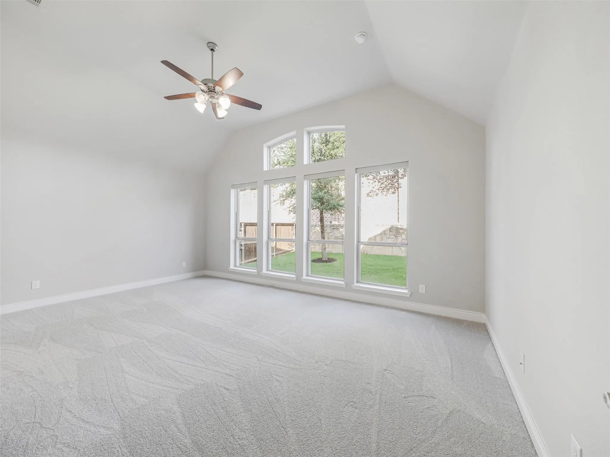 The primary suite provides a spacious retreat with a vaulted ceiling and abundant natural light.