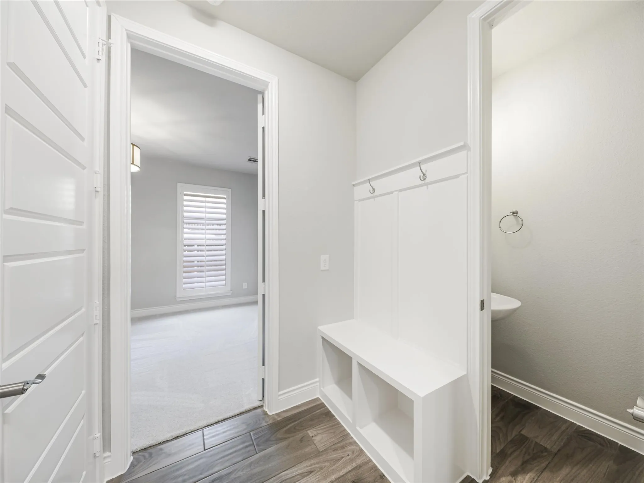 Practical details have been incorporated throughout the home's design. A dedicated mud room with built-in storage provides an organized transition area for shoes, bags, and everyday essentials.