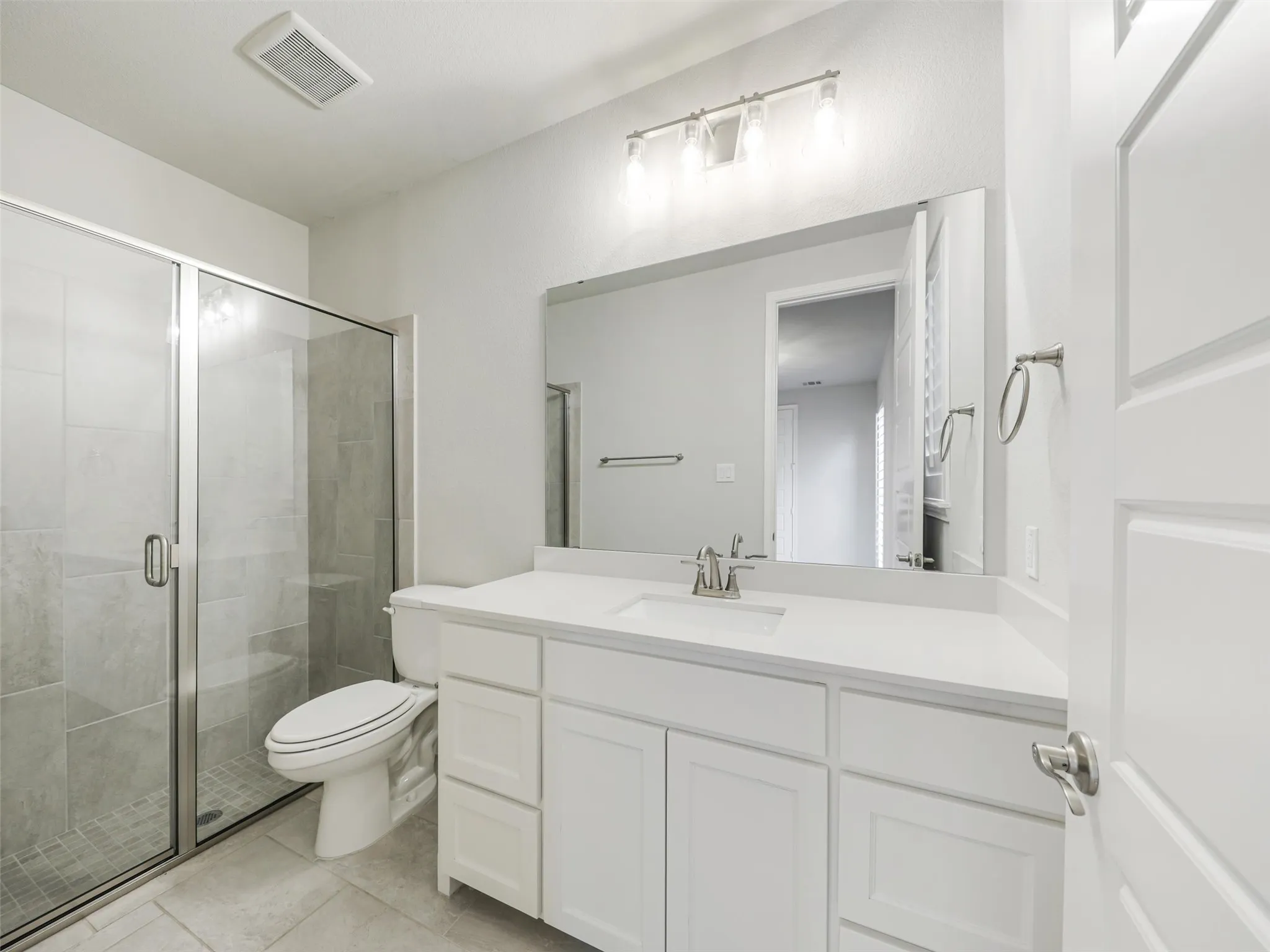 A secondary bedroom located on the first floor offers additional flexibility and privacy. Complete with its own walk-in closet and private ensuite bathroom, this space is well suited for overnight guests, extended stays, or a private secondary suite.
