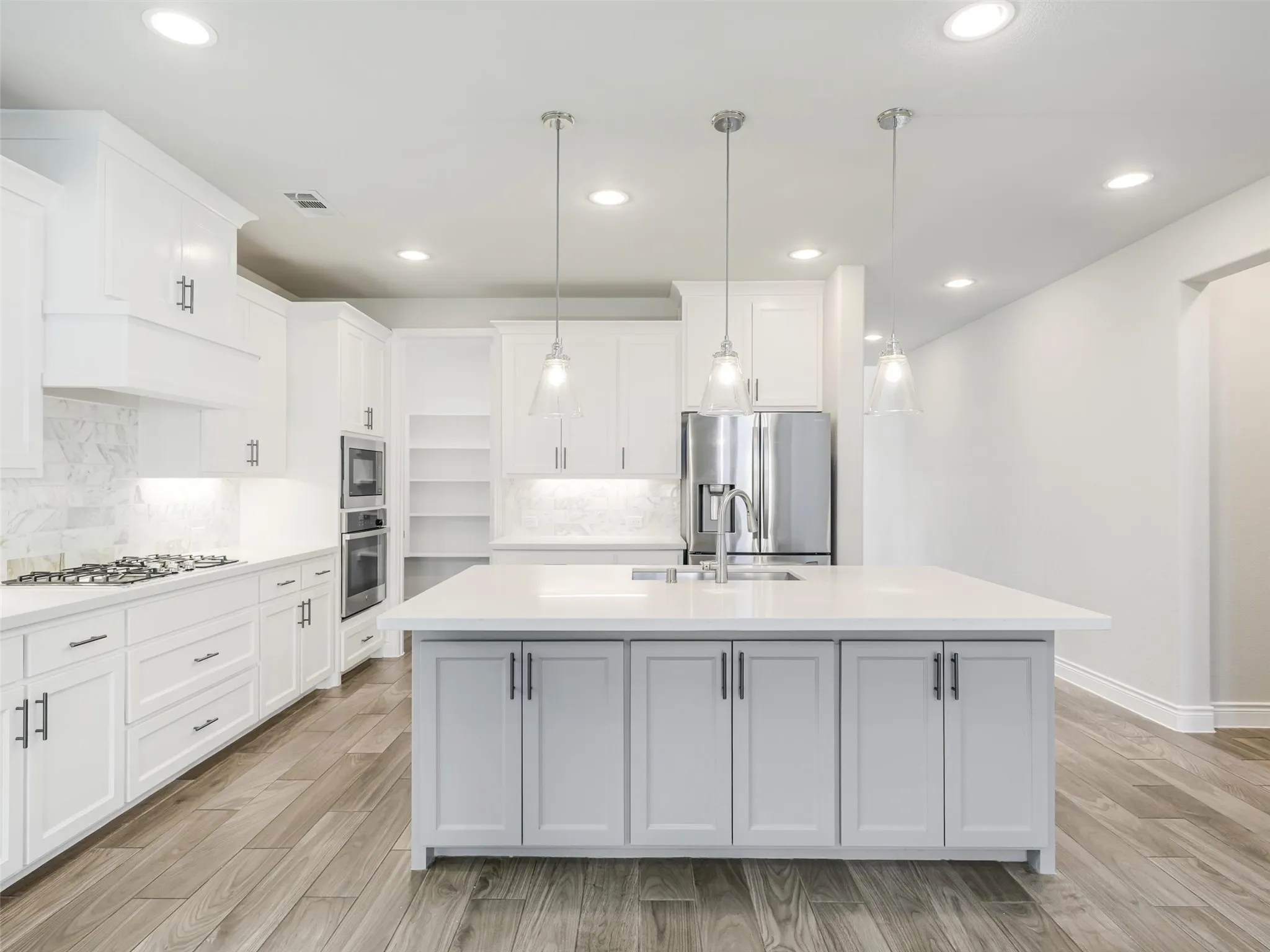 The kitchen opens to the impressive living room, where a soaring cathedral ceiling adds volume and architectural interest.
