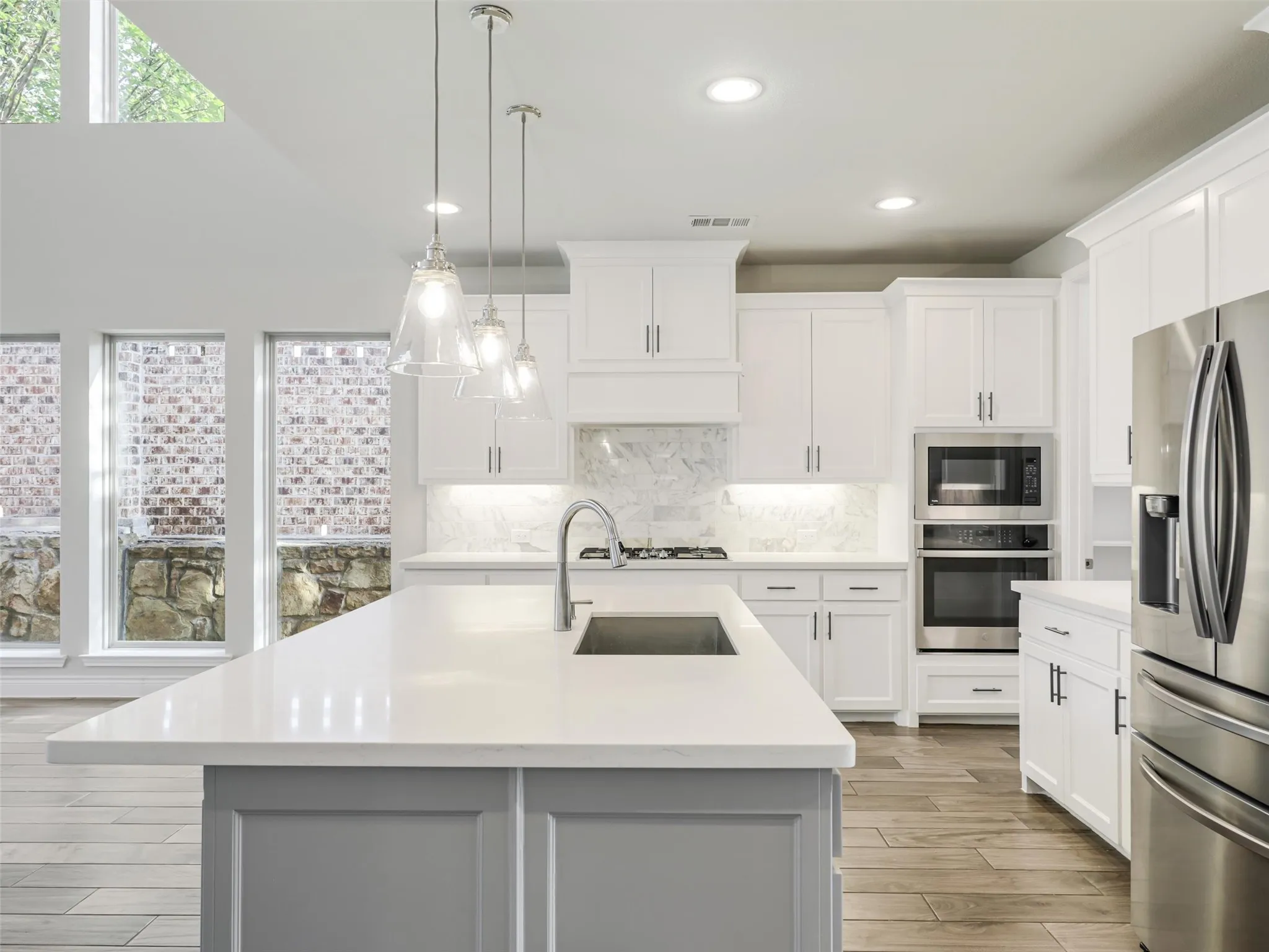 The kitchen opens to the impressive living room, where a soaring cathedral ceiling adds volume and architectural interest.