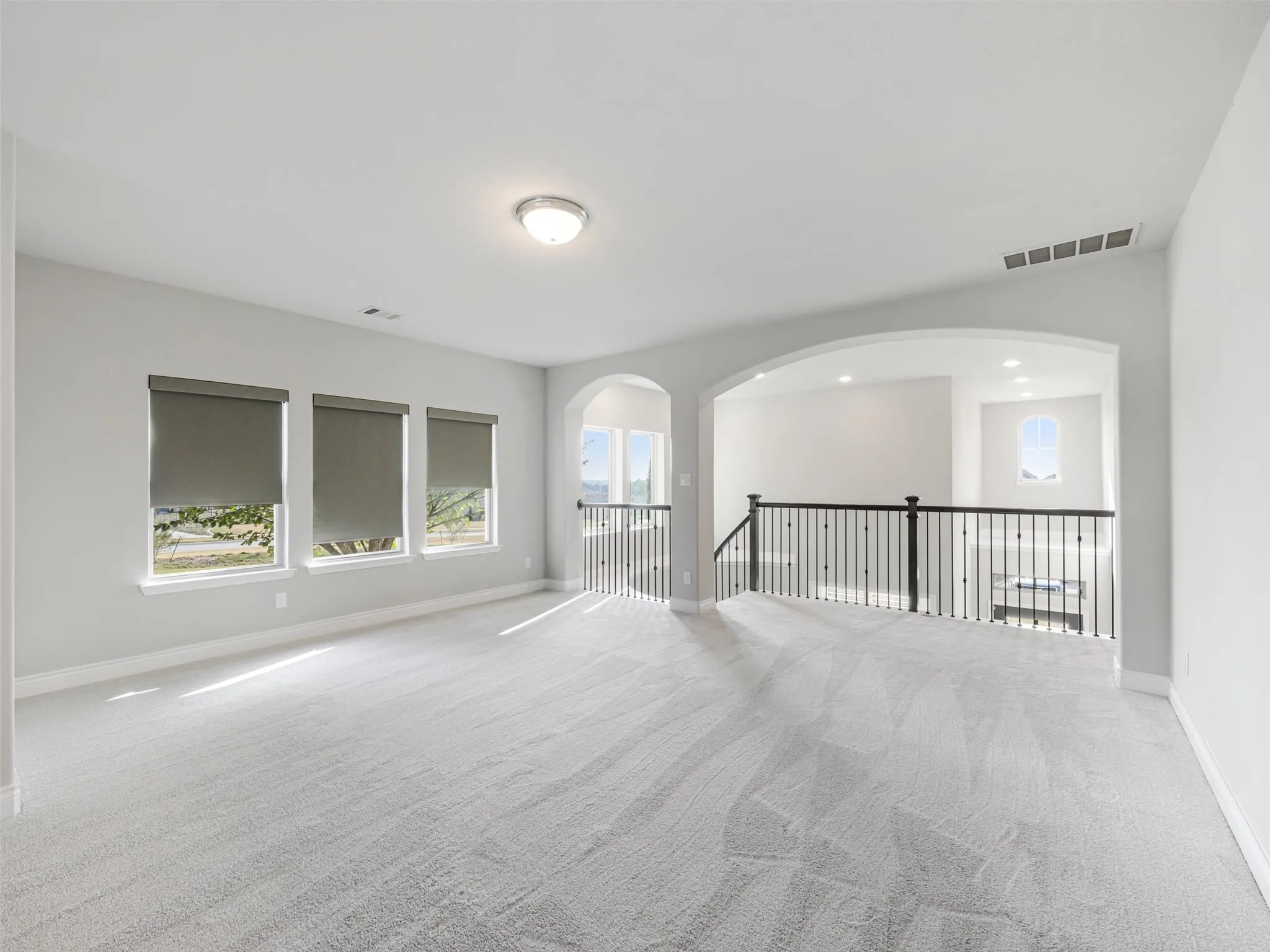The game room provides a versatile area for recreation, movies, hobbies, or an additional lounge. A balcony overlooking the living room below enhances the home's open design and provides a dramatic view of the cathedral ceiling and main gathering space.