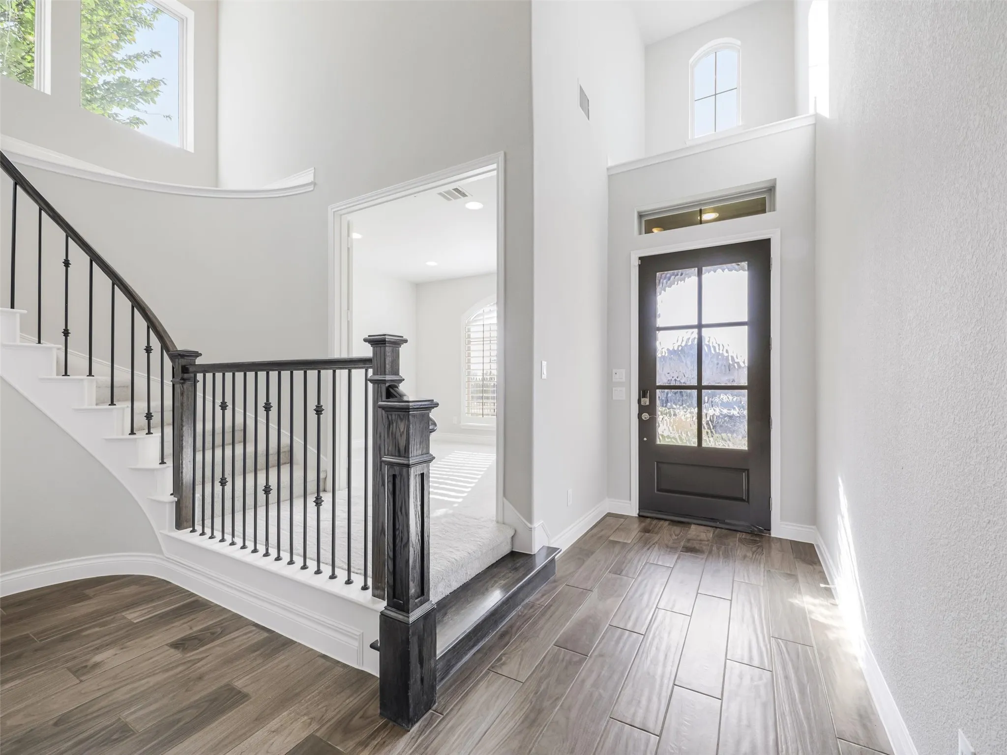 From the moment you step inside, the open layout, luxury vinyl plank flooring, recessed lighting, and graceful curved staircase create an inviting first impression and set the tone for the spacious interiors beyond.