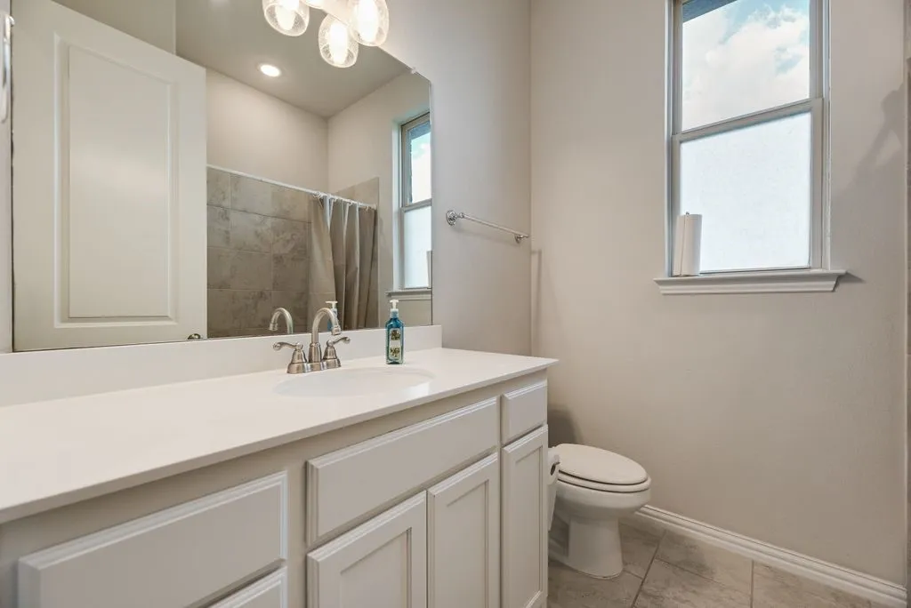 Bathroom featuring a single vanity with white cabinetry, white countertop, and an integrated sink