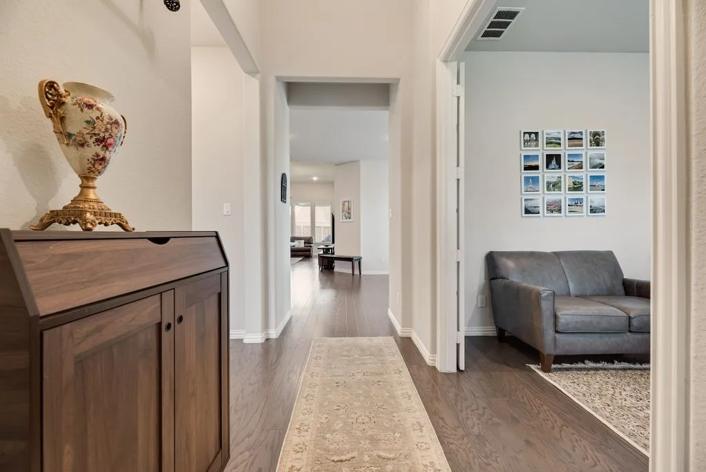 Hallway featuring wood-finish flooring, a neutral color palette, and recessed lighting