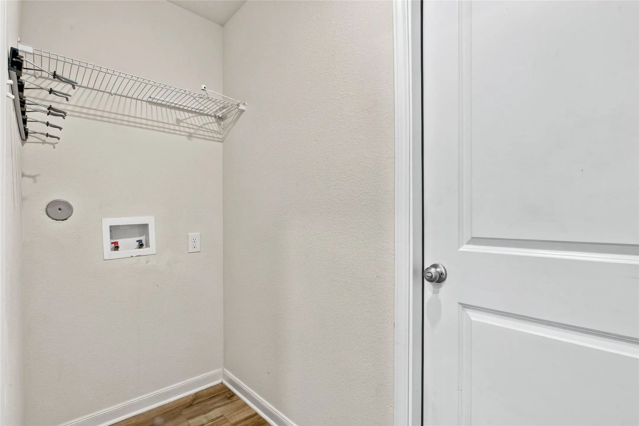 Laundry Room that has Washer and Dryer hookups and some Shelving for Storage