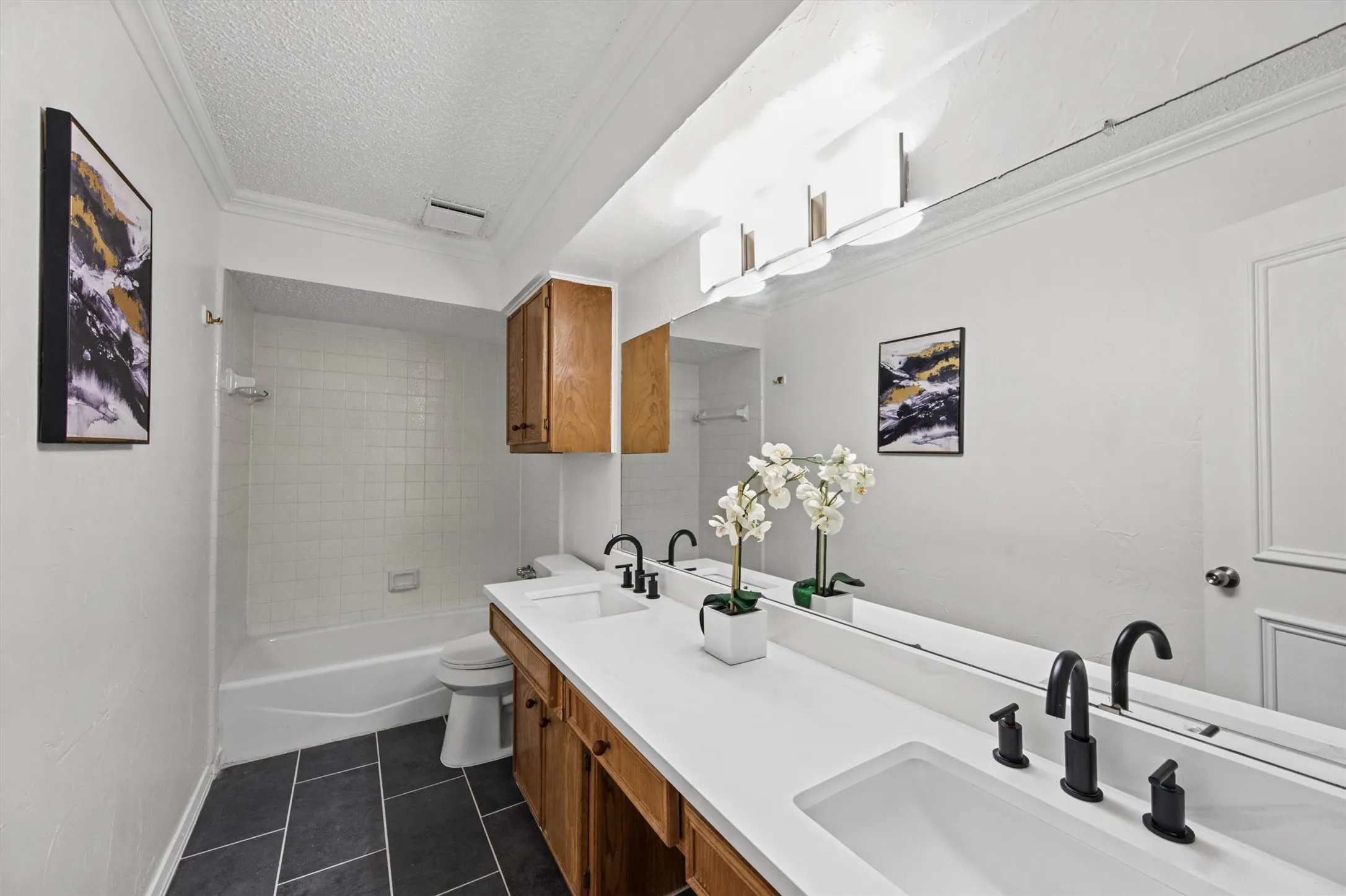 Double vanity with integrated sinks, matte black fixtures, and a continuous mirror