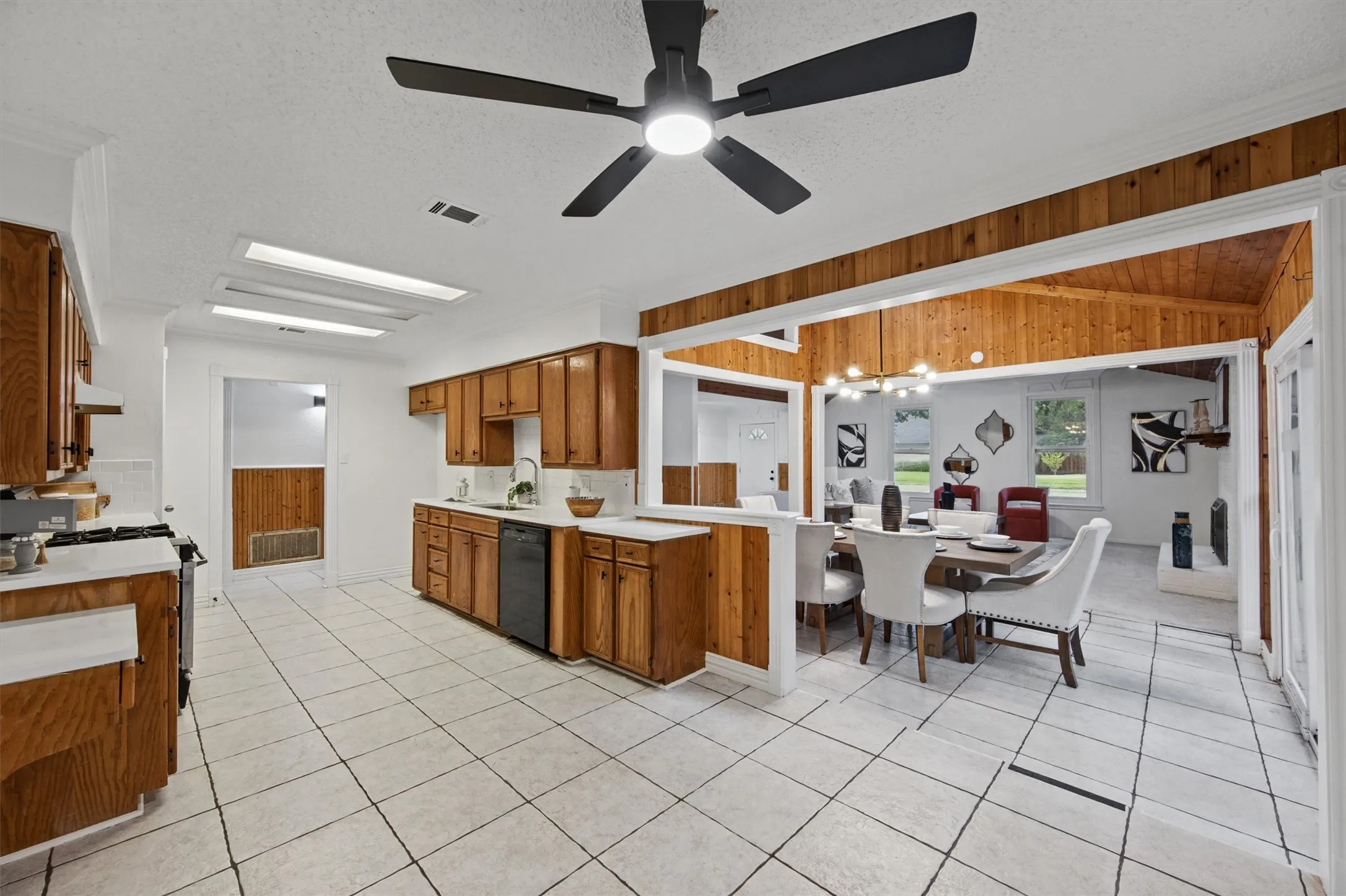 Kitchen with wood-finish cabinetry, white tile flooring, and integrated appliances