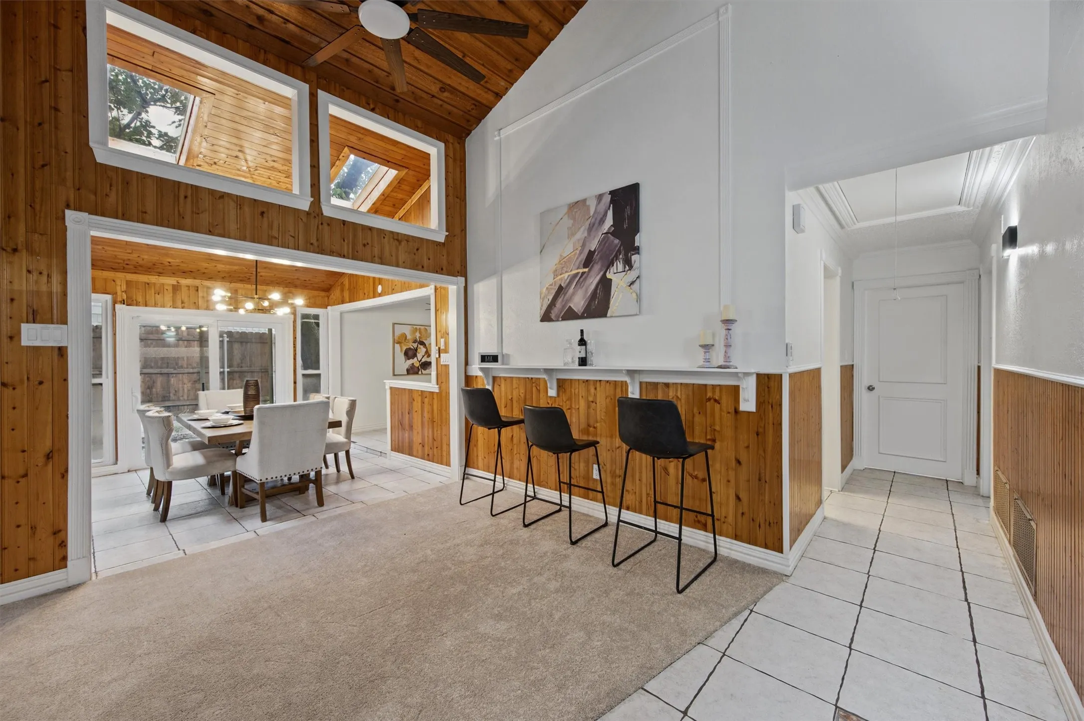 Vaulted wood-paneled ceiling with skylights and a ceiling fan
