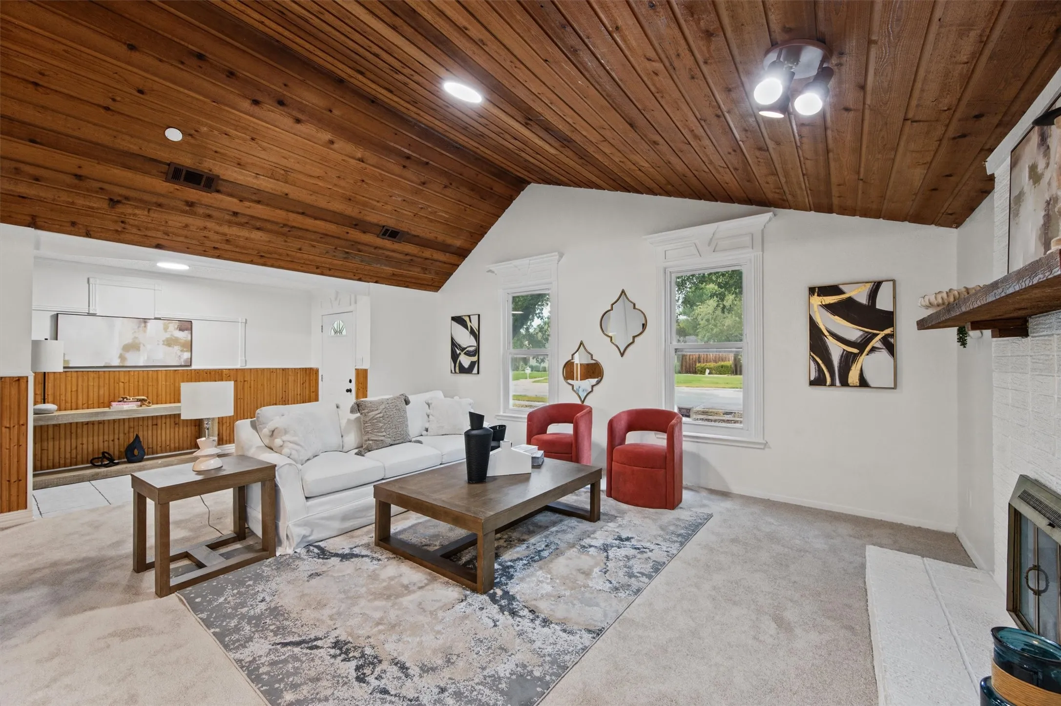 Vaulted wood-paneled ceiling, white walls, and light-colored carpet
