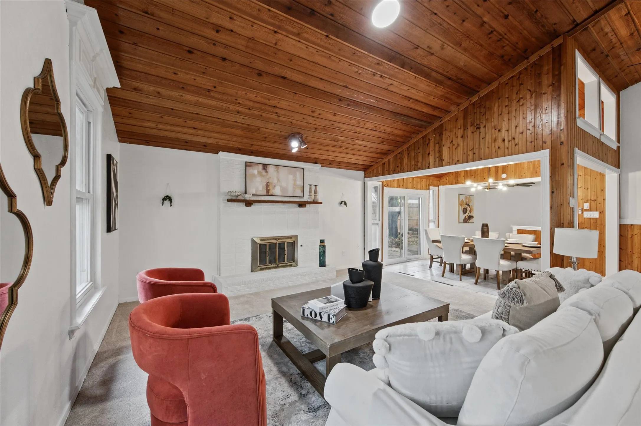 Vaulted wood-paneled ceiling, white painted brick fireplace with mantel, recessed lighting, and wood-finish flooring