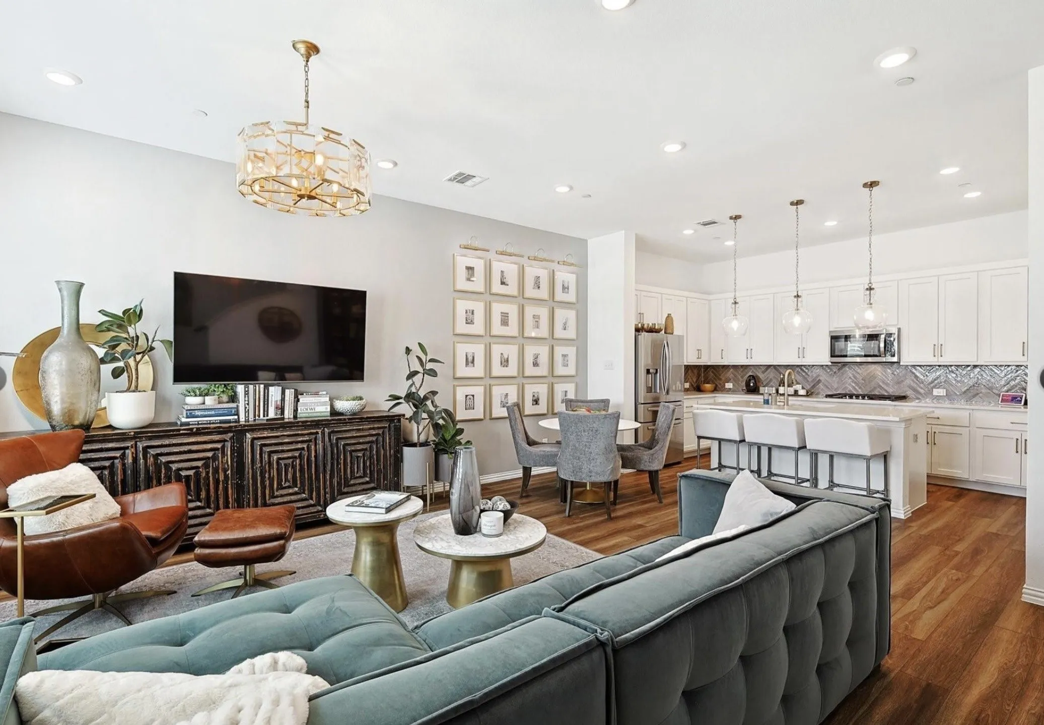 Open-concept living area featuring wood-finish flooring, recessed lighting, and a decorative chandelier
