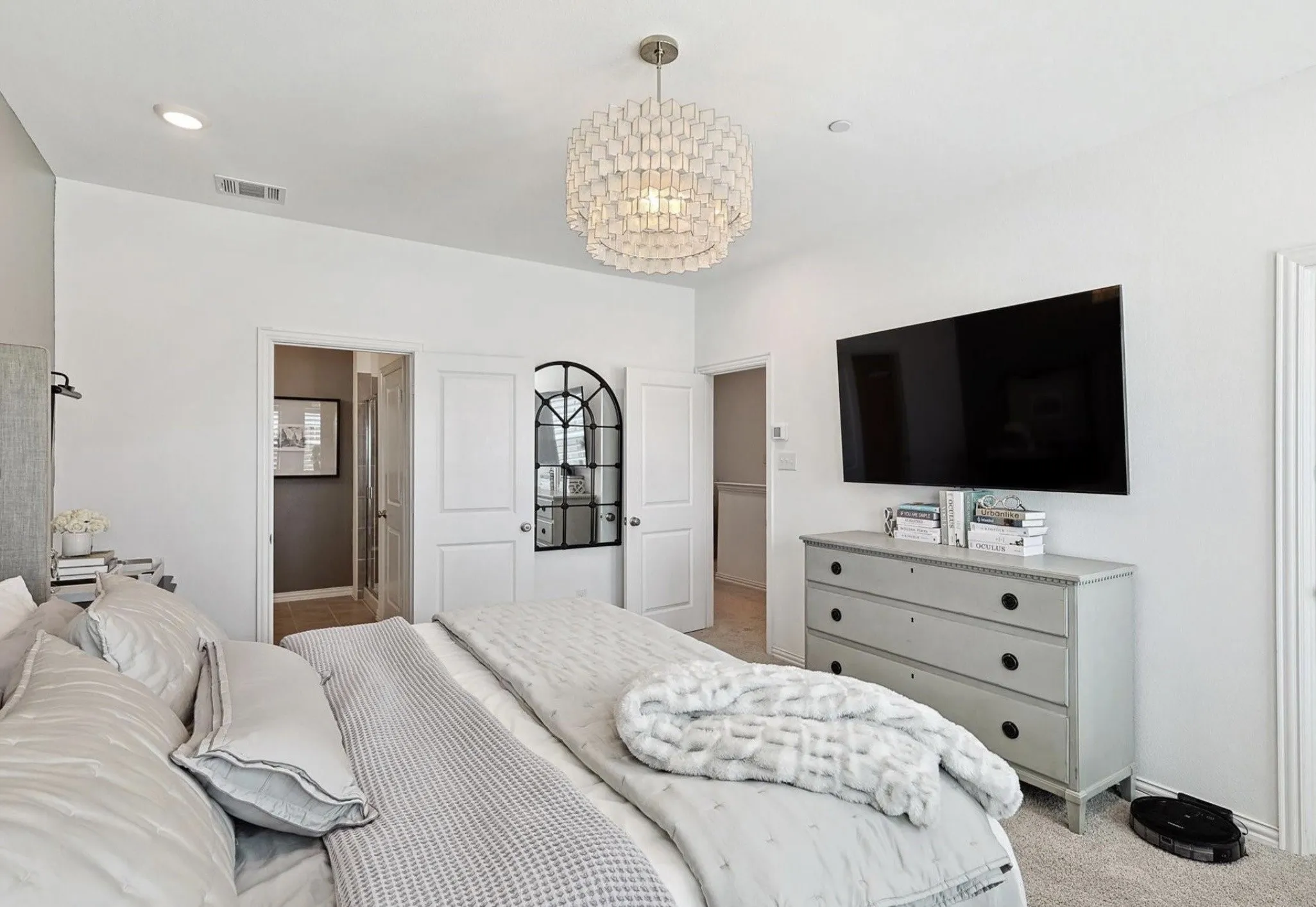 Recessed lighting, contemporary chandelier, ceiling-mounted television, and arch-top mirrored doors